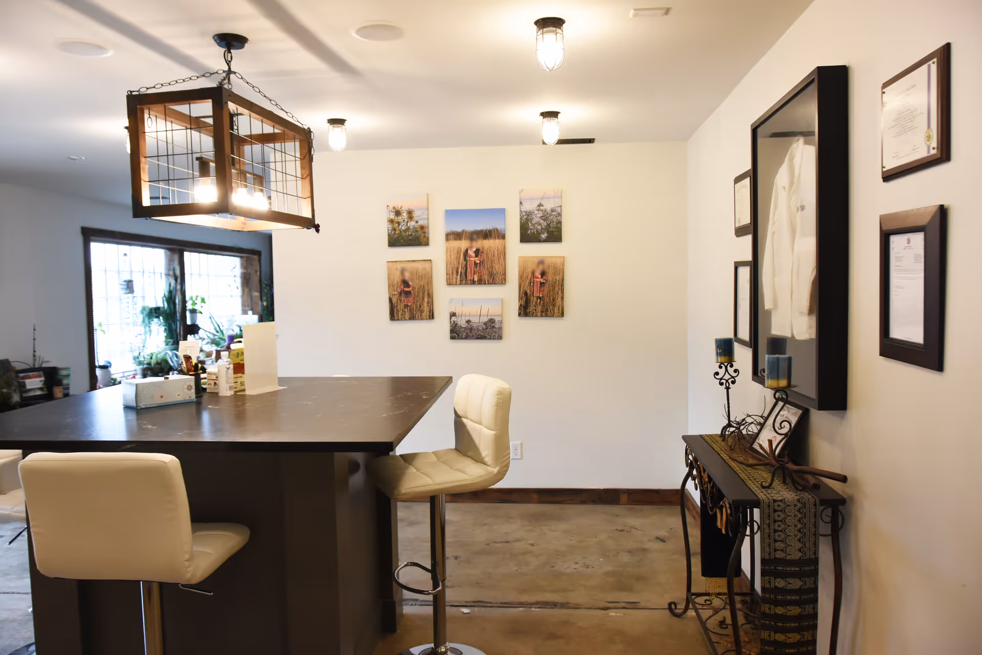 Modern interior lounge with a high counter, cream stools, wall decor, and certificates.