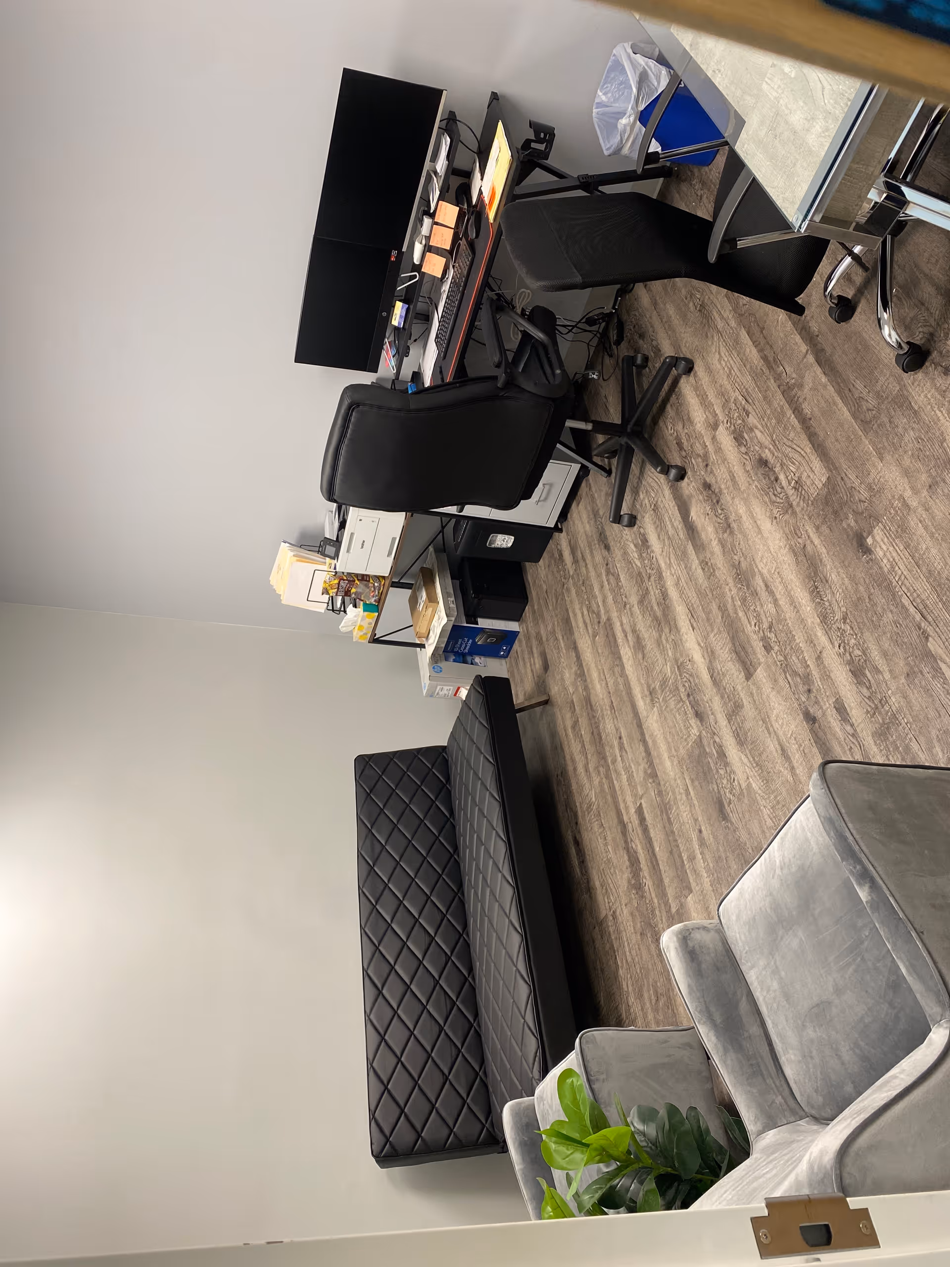 Office space with desk, chair, printer, and seating in a senior living facility reception.