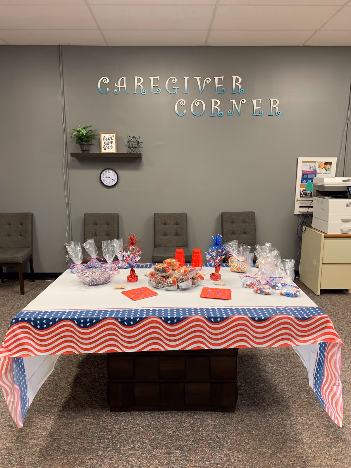 Patriotic-themed party table in a care facility interior beneath the Caregiver Corner sign
