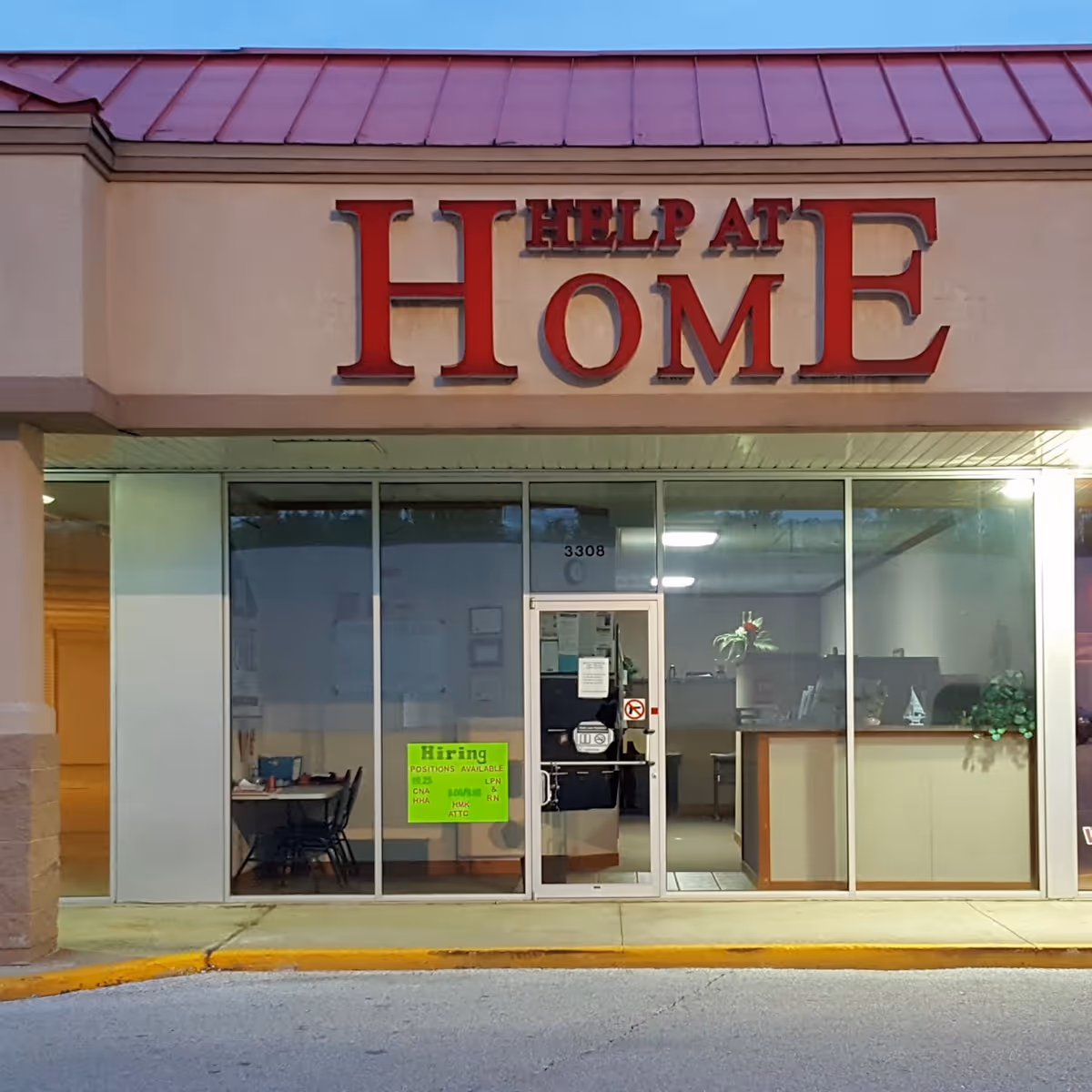 Front of a facility storefront with a large HELP AT HOME sign and glass entrance.