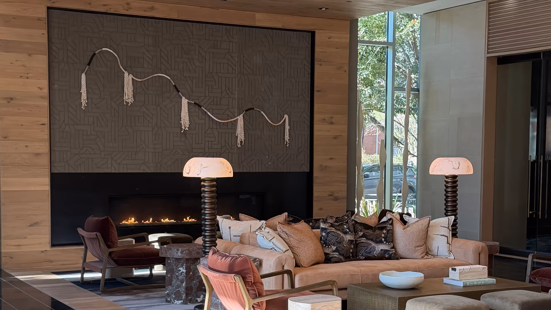 Cozy lounge area with a fireplace, sofas, and decorative lamps.