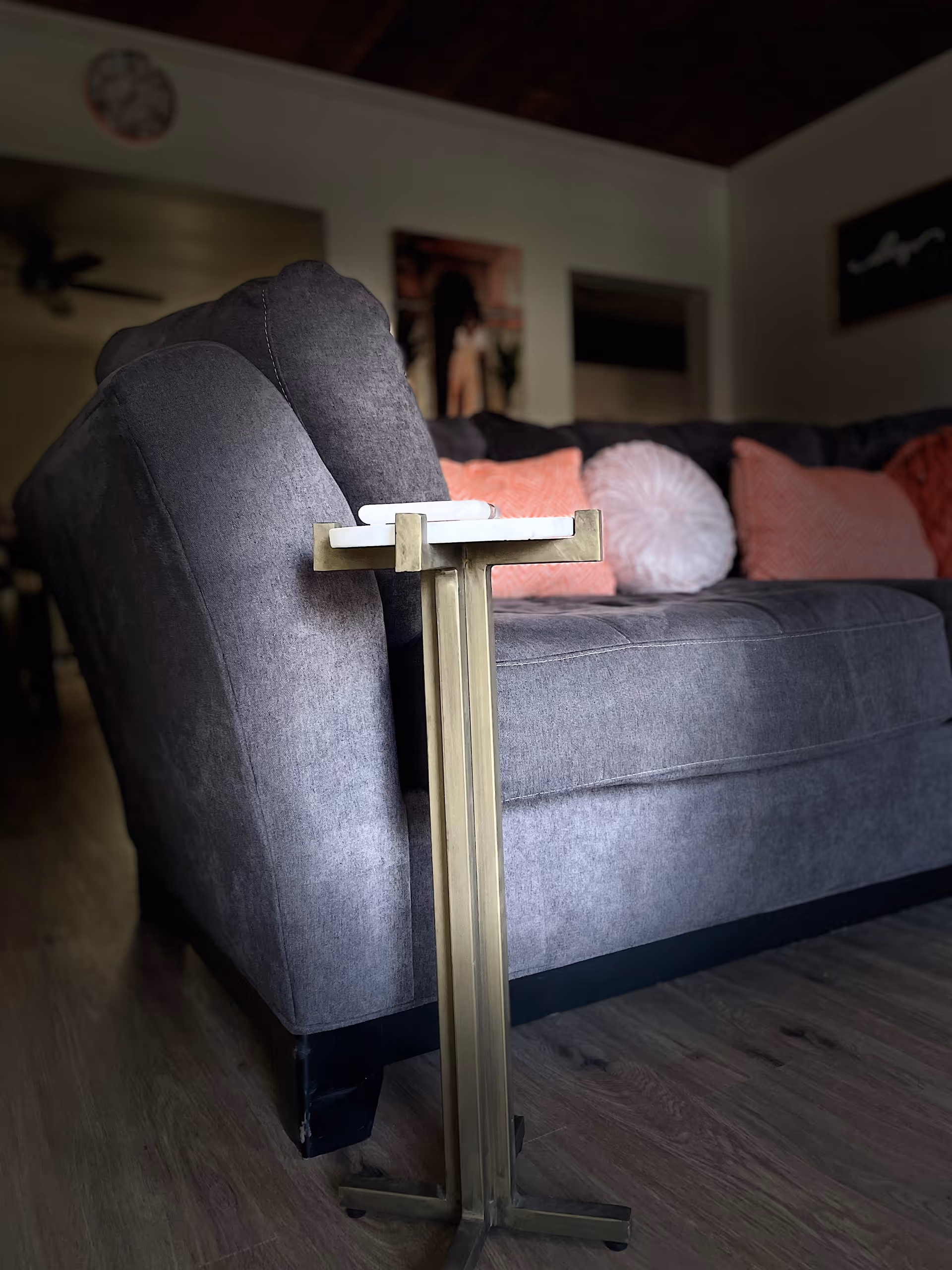 Close up of a gray sofa with pink cushions in a cozy living room.