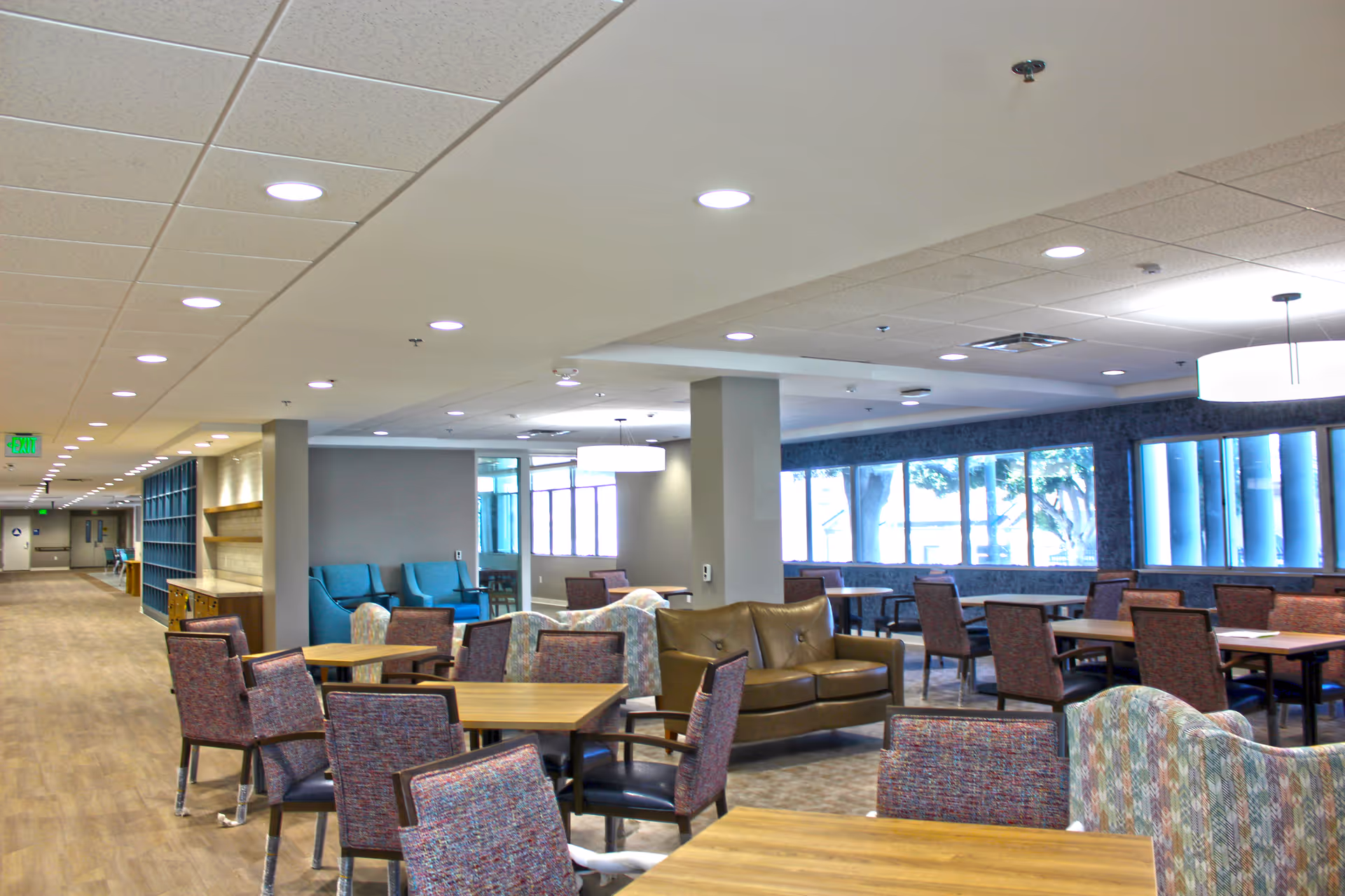 Spacious interior common area with seating, tables, and large windows.