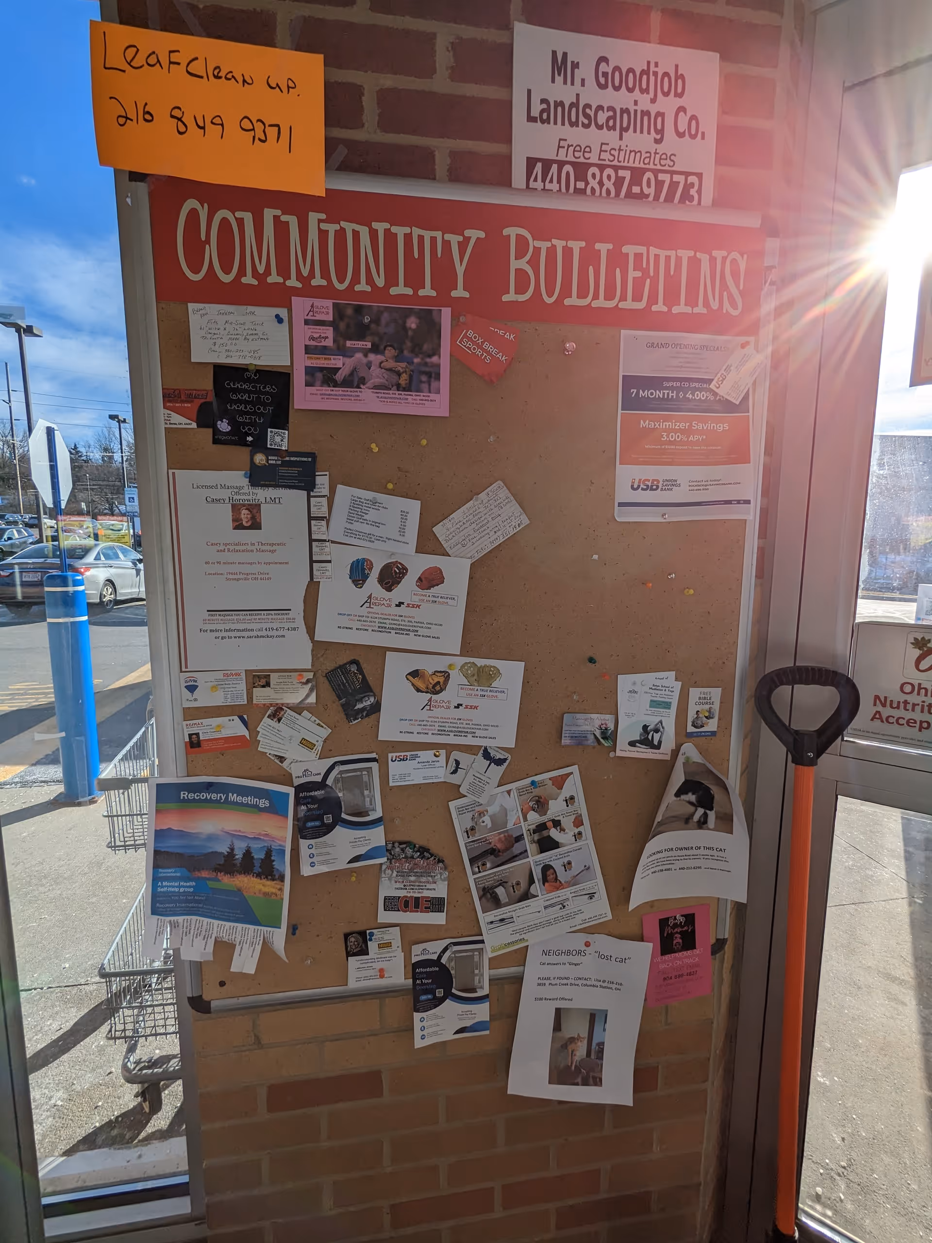 A bulletin board labeled Community Bulletins with assorted notices inside a brick entrance.