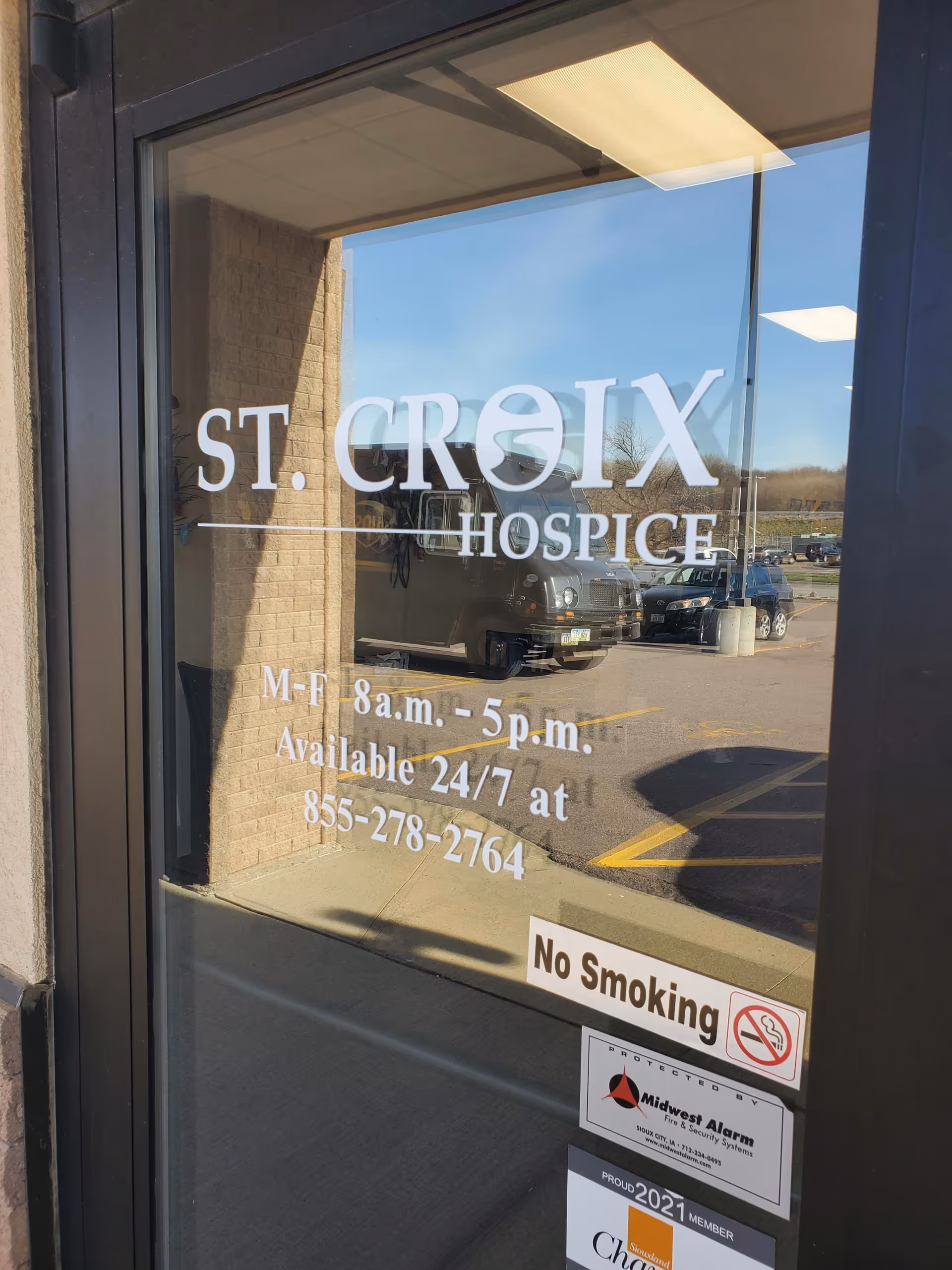 Glass front entrance displays St. Croix Hospice branding, hours, and a No Smoking sign.