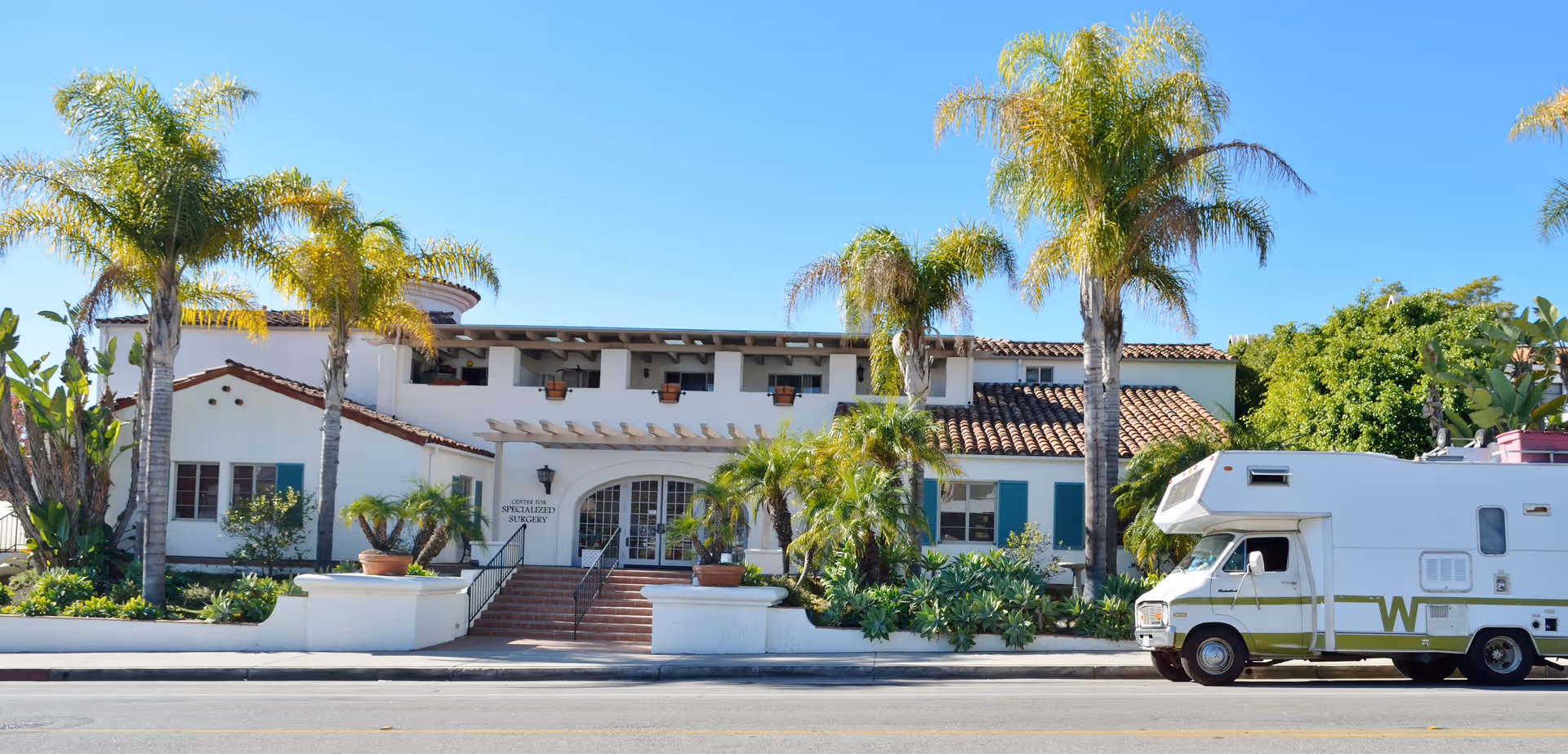 Front view of The Center for Specialized Surgery building with palm trees and an ambulance.