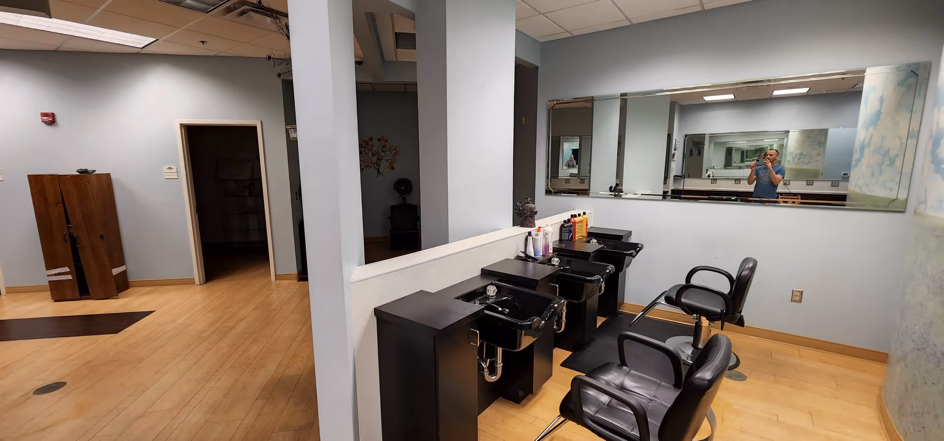 Hair salon area with sinks, chairs, and mirrors inside a senior living facility.