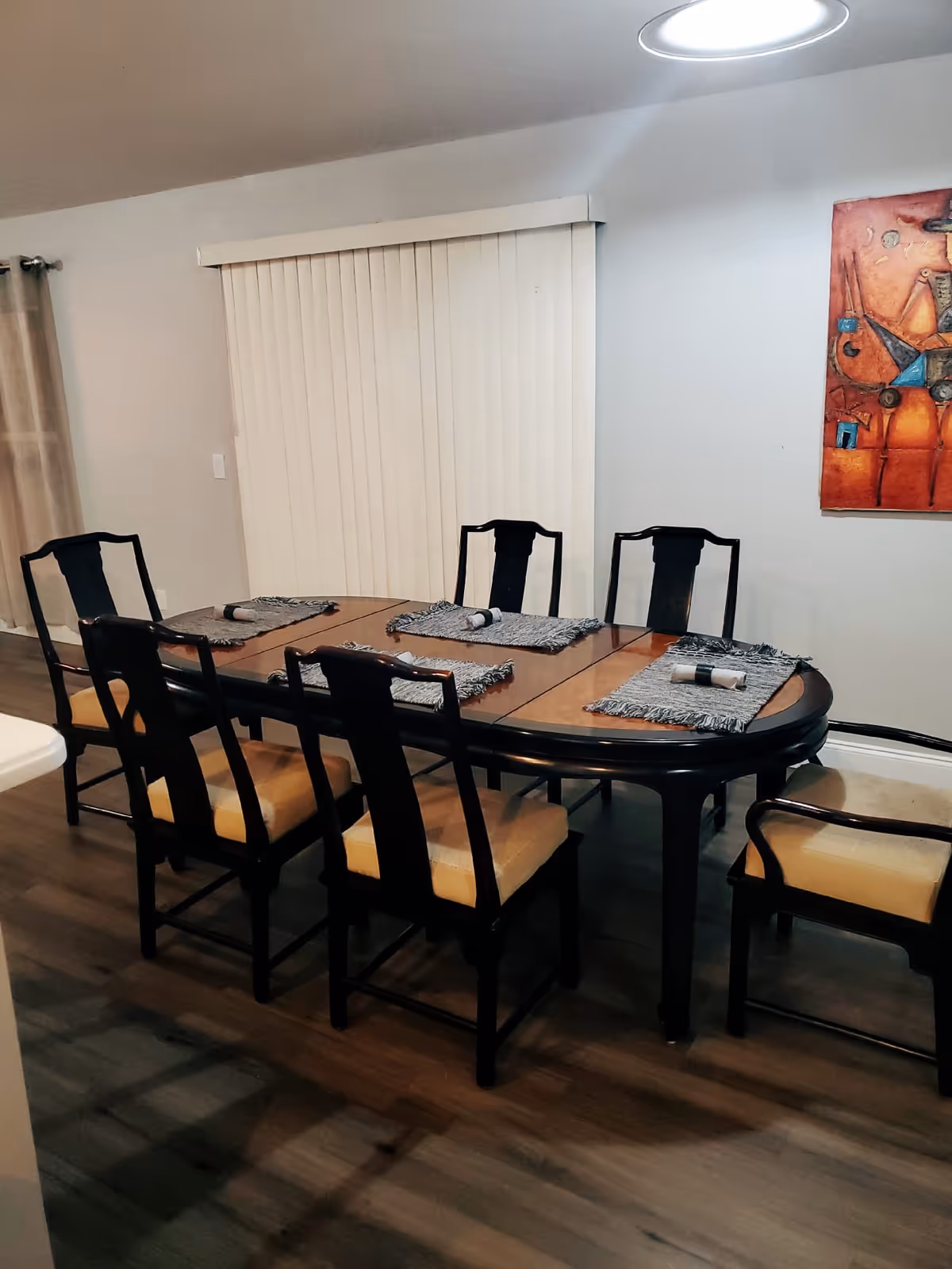 Dining room with a large table, six chairs, and placemats.