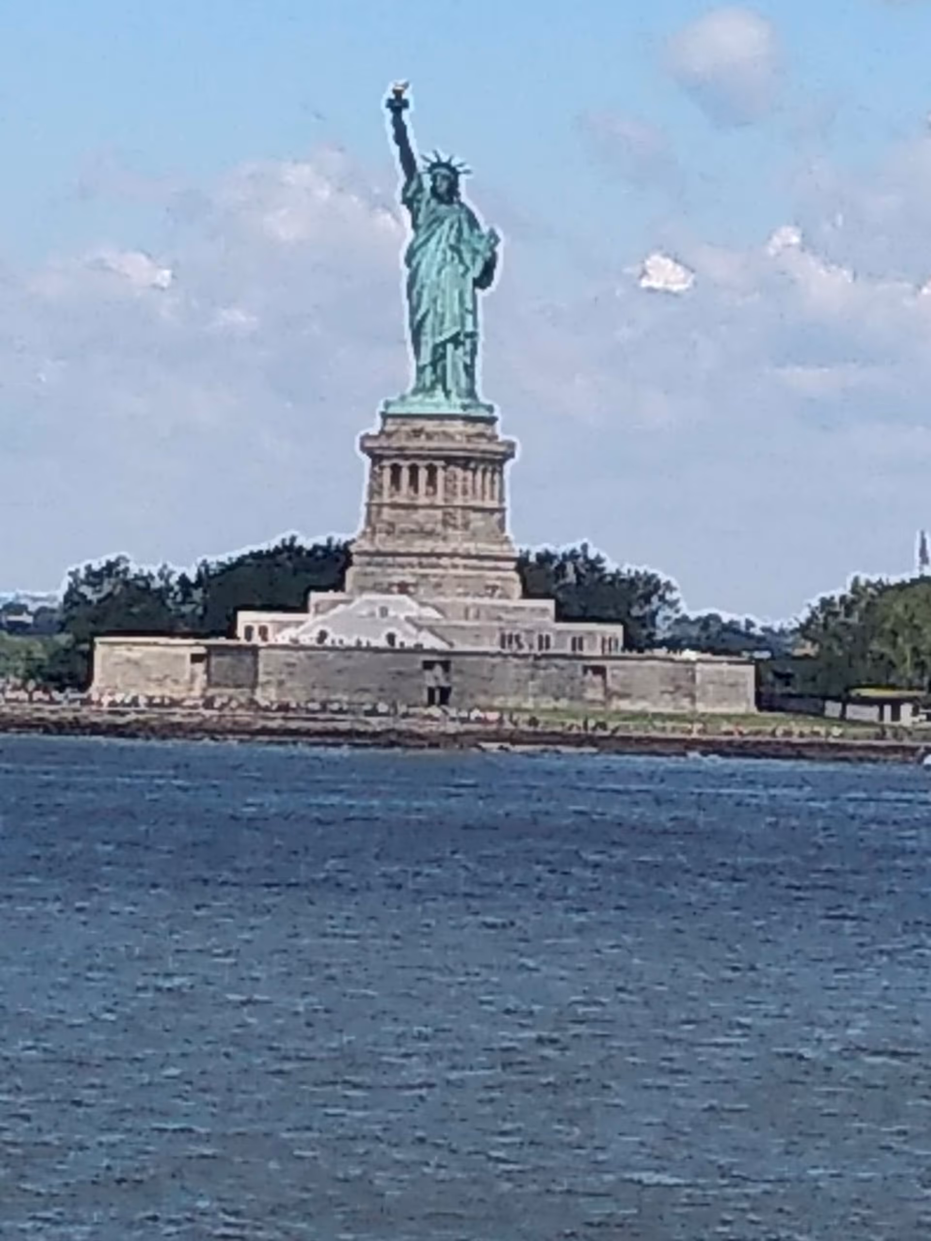 Statue of Liberty on its pedestal, viewed across the harbor.
