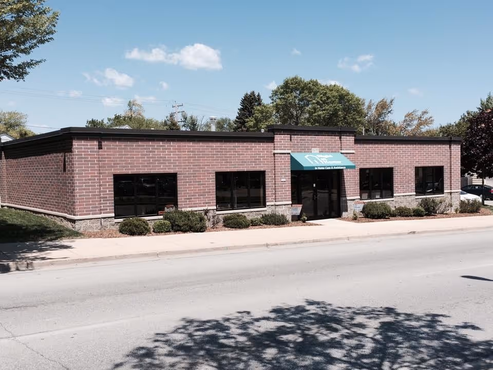 Front view of a single-story brick building with a green awning entrance.