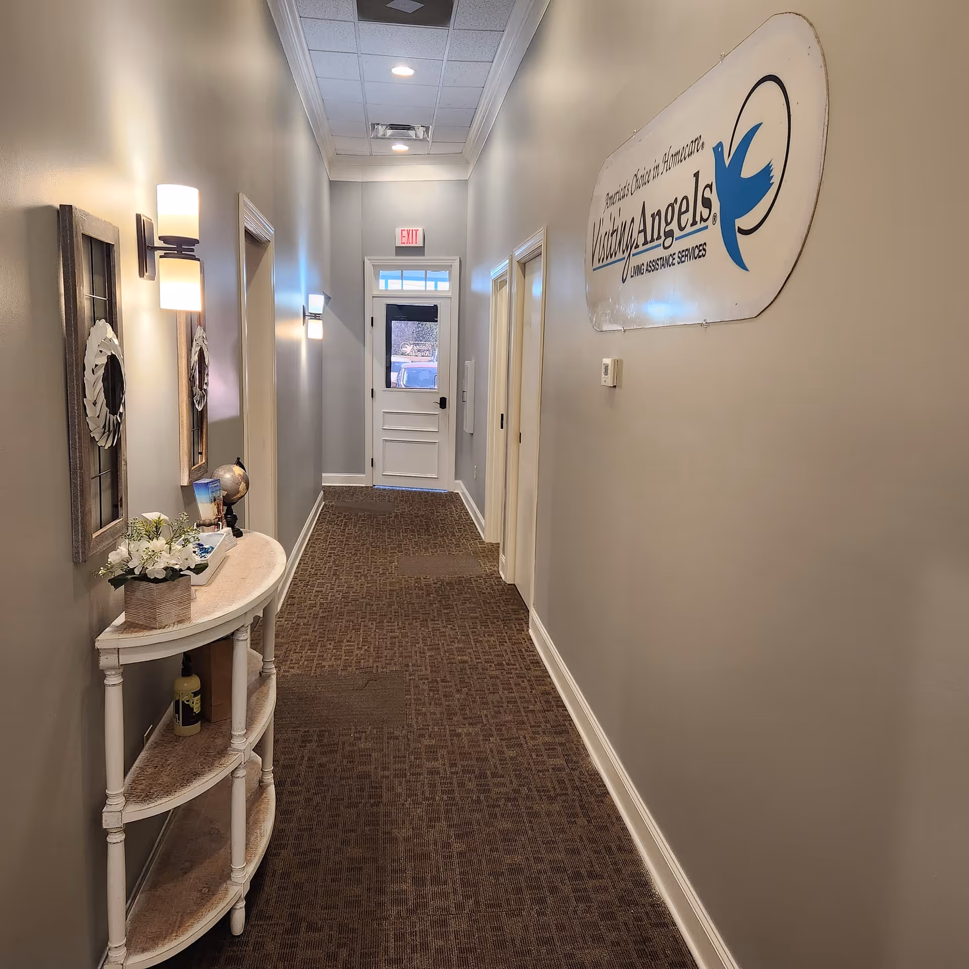 Long hallway in a Visiting Angels senior home care facility with a wall sign.