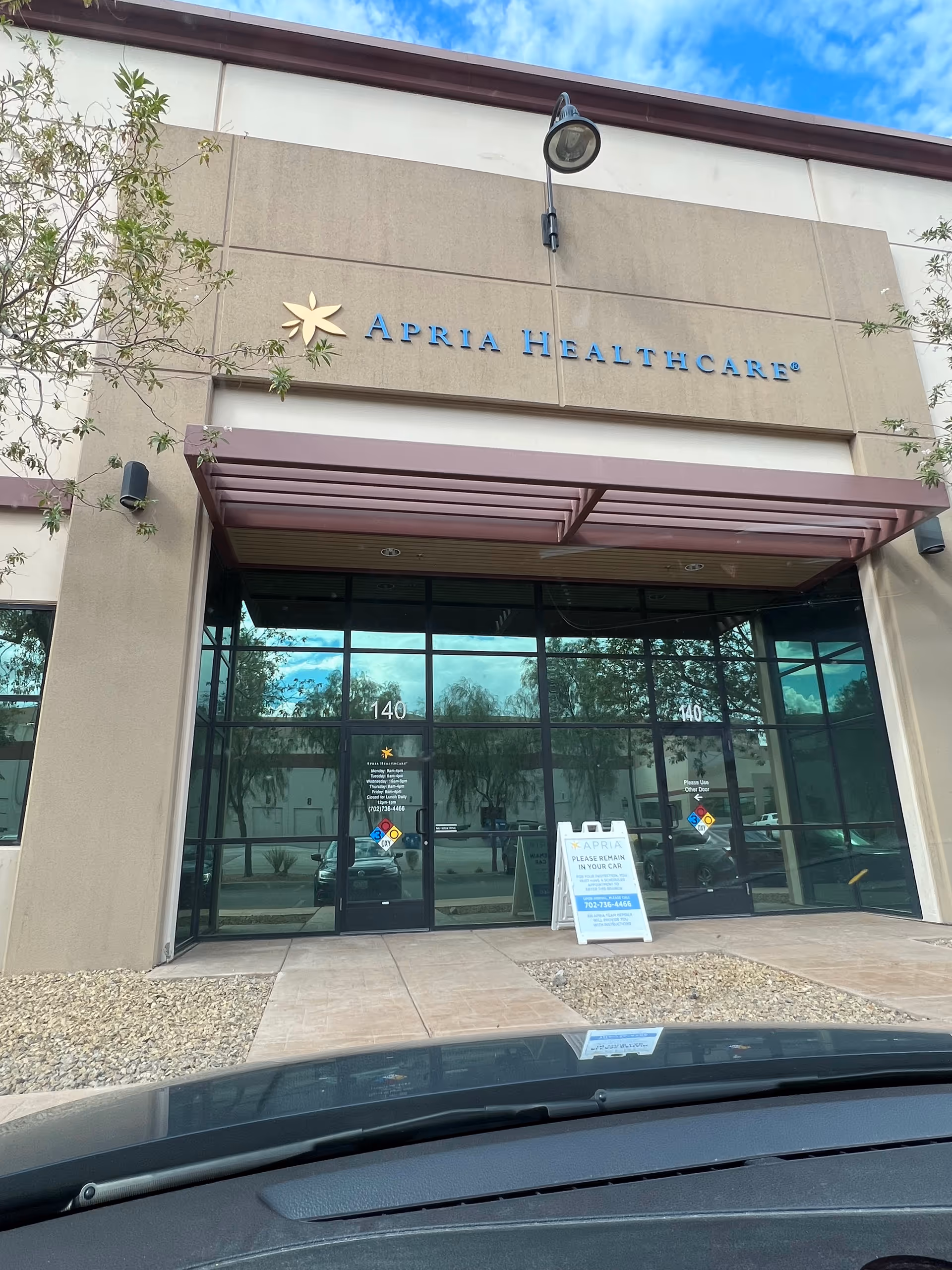 Exterior view of Apria Healthcare building entrance with glass doors and signage.