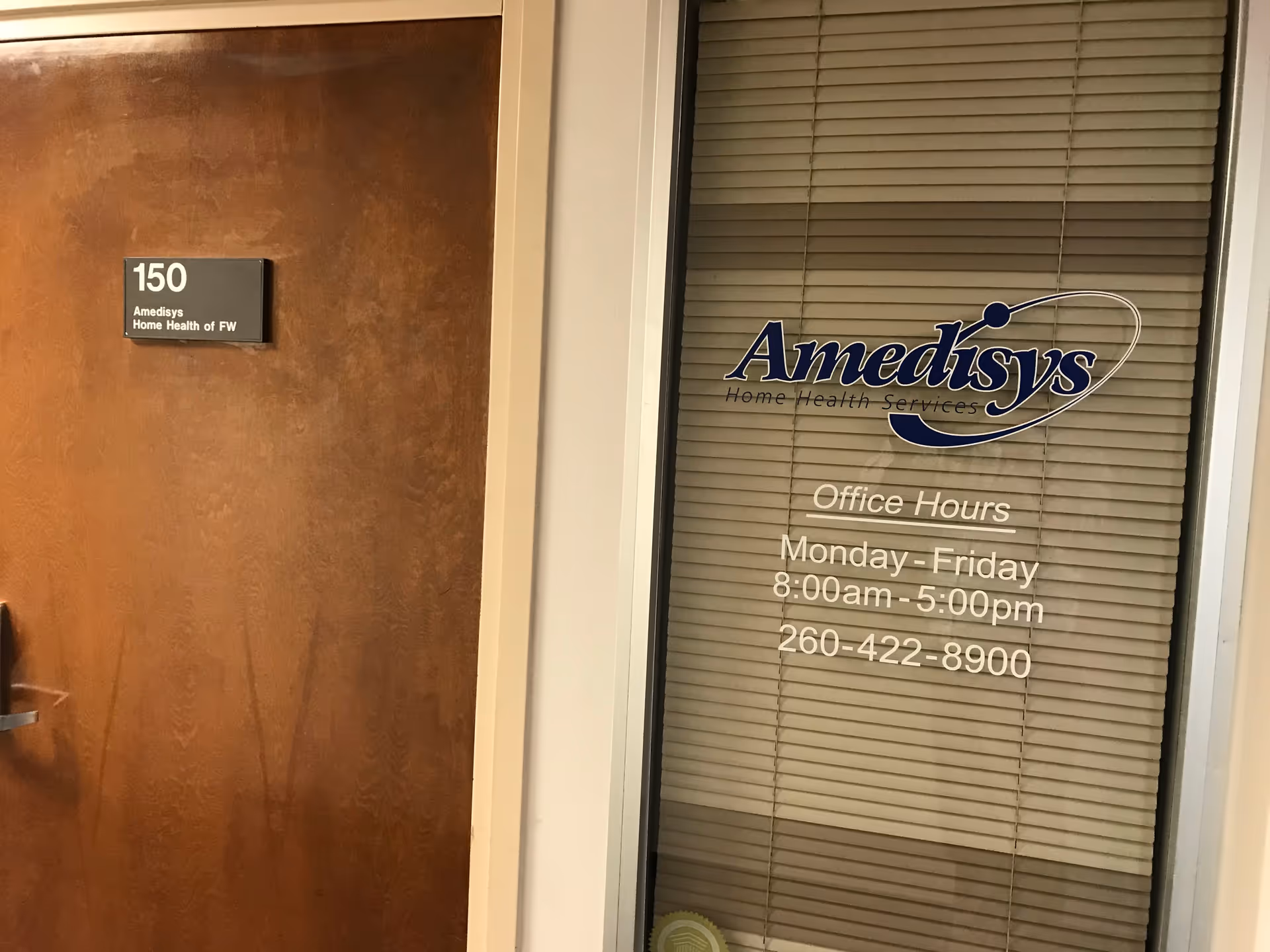 Door and window sign in hallway displaying Adoration Home Health office hours.