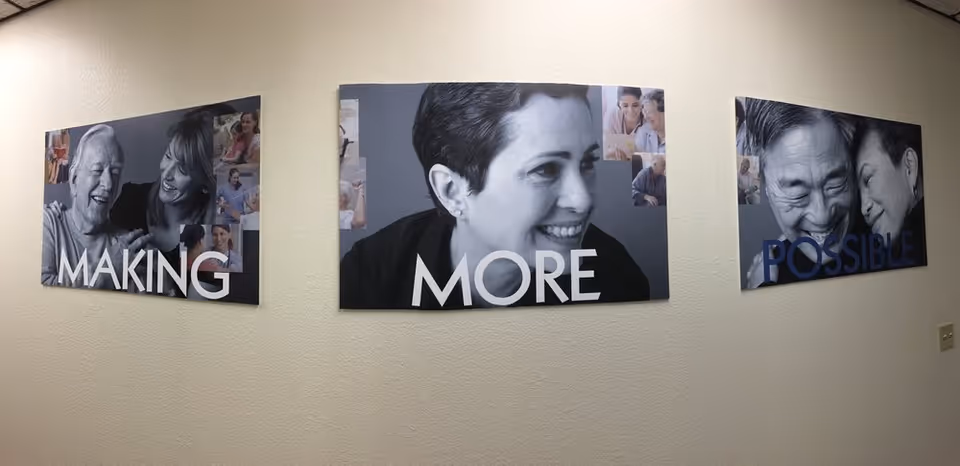 Three wall panels with grayscale photos and the text 'MAKING MORE POSSIBLE' decorate a hallway.