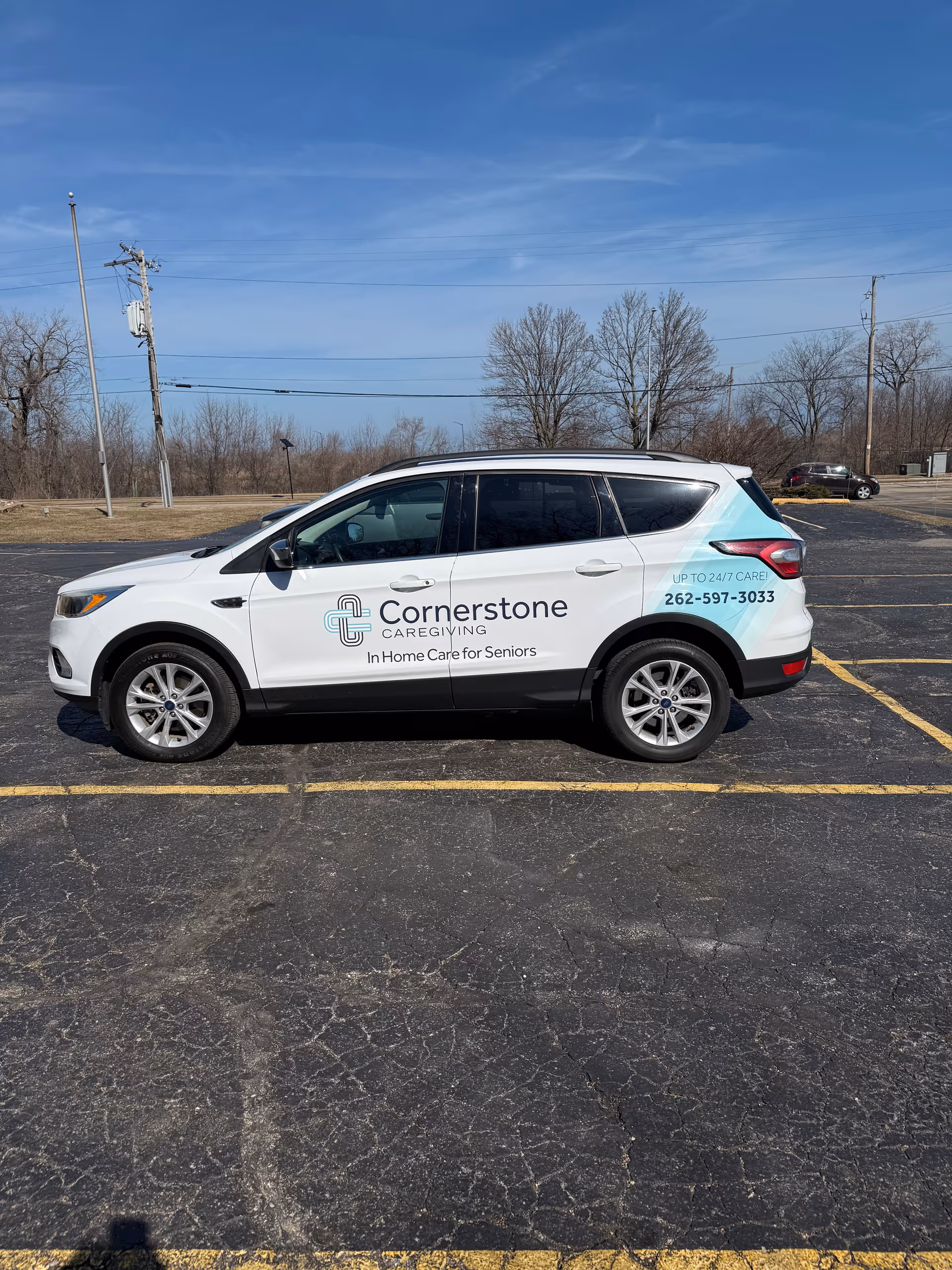 A white Cornerstone Caregiving van with logo parked in a lot.