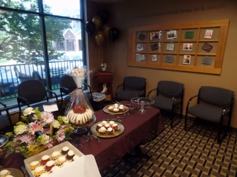 Refreshments table with cupcakes and pastries in a cozy senior living common area.