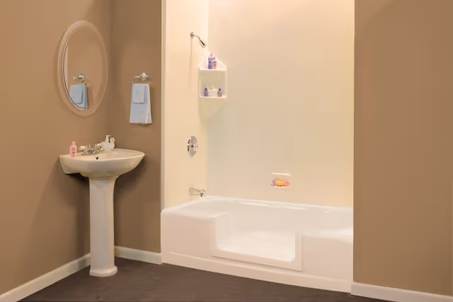 Senior-living bathroom with pedestal sink, mirror, towel, shelf, and built-in tub.