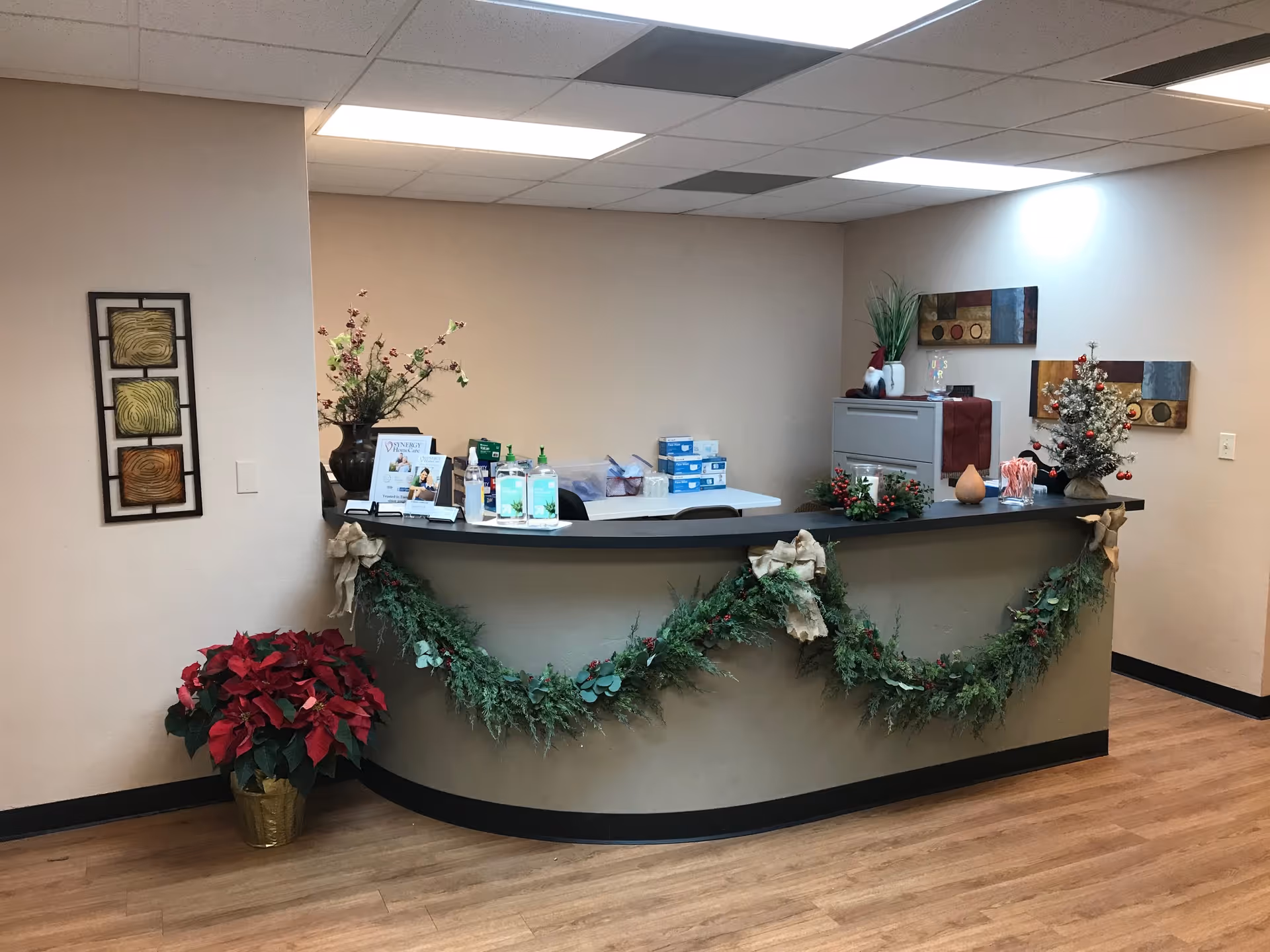 Curved reception desk with holiday garland and decor in a quiet interior lobby