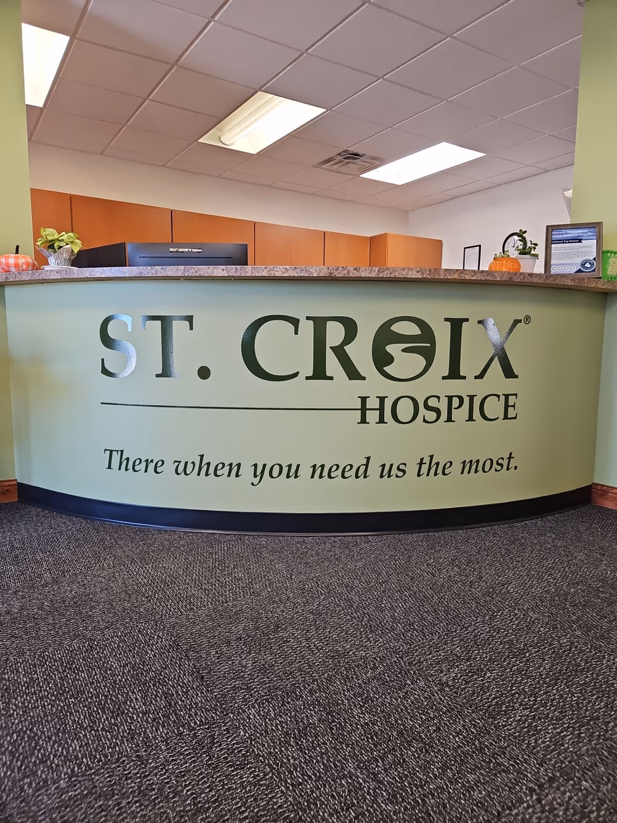 Curved reception desk with St. Croix Hospice signage in a modern lobby.