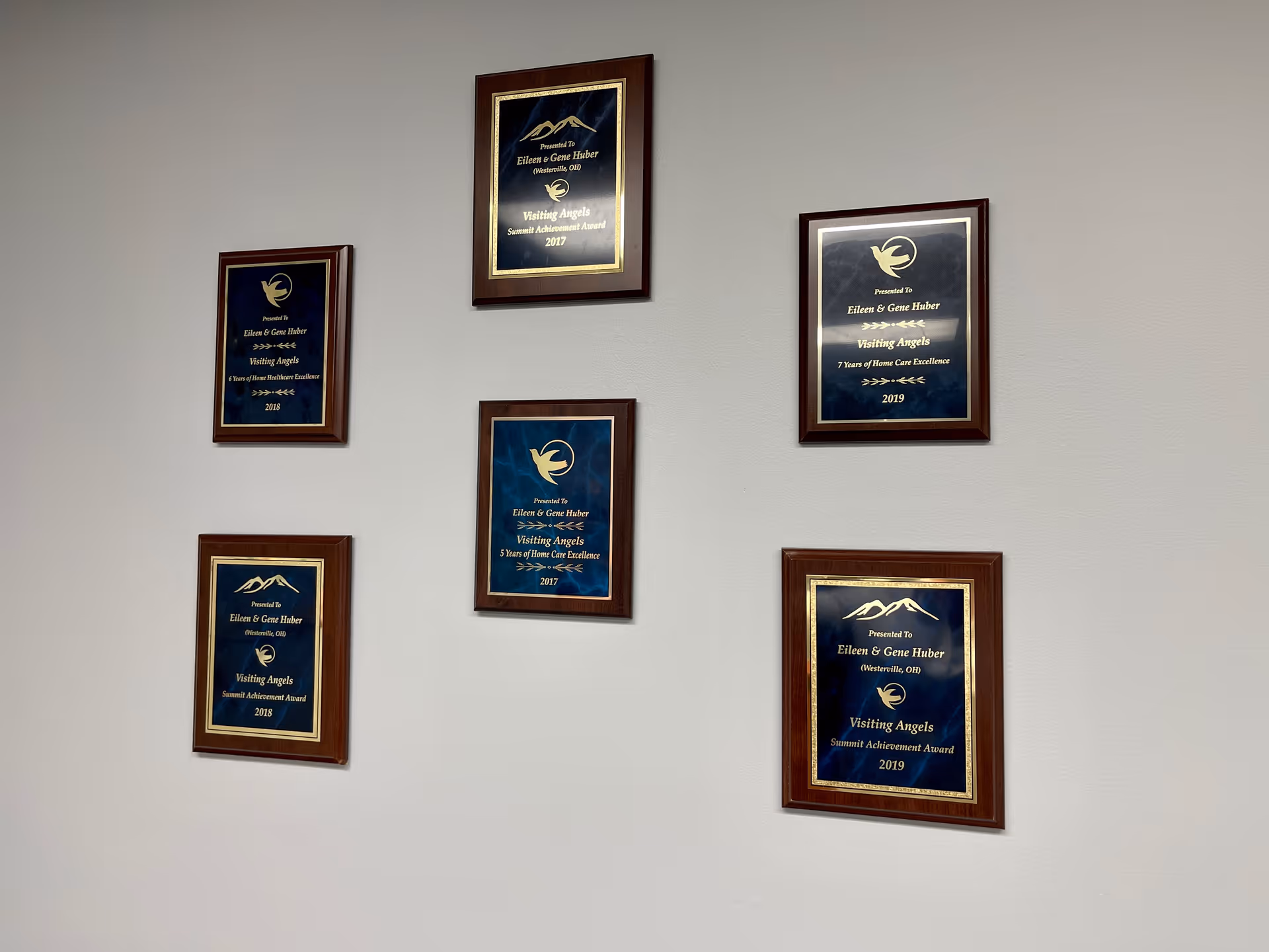 Wall with framed award plaques arranged in a staggered grid.