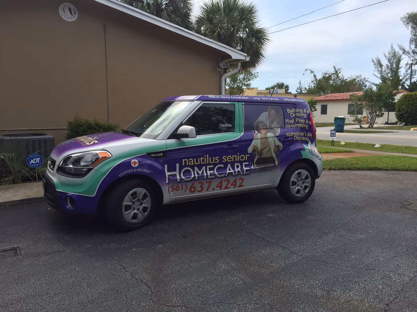 Colorful Nautilus Senior Home Care van parked in a lot outside a beige building.