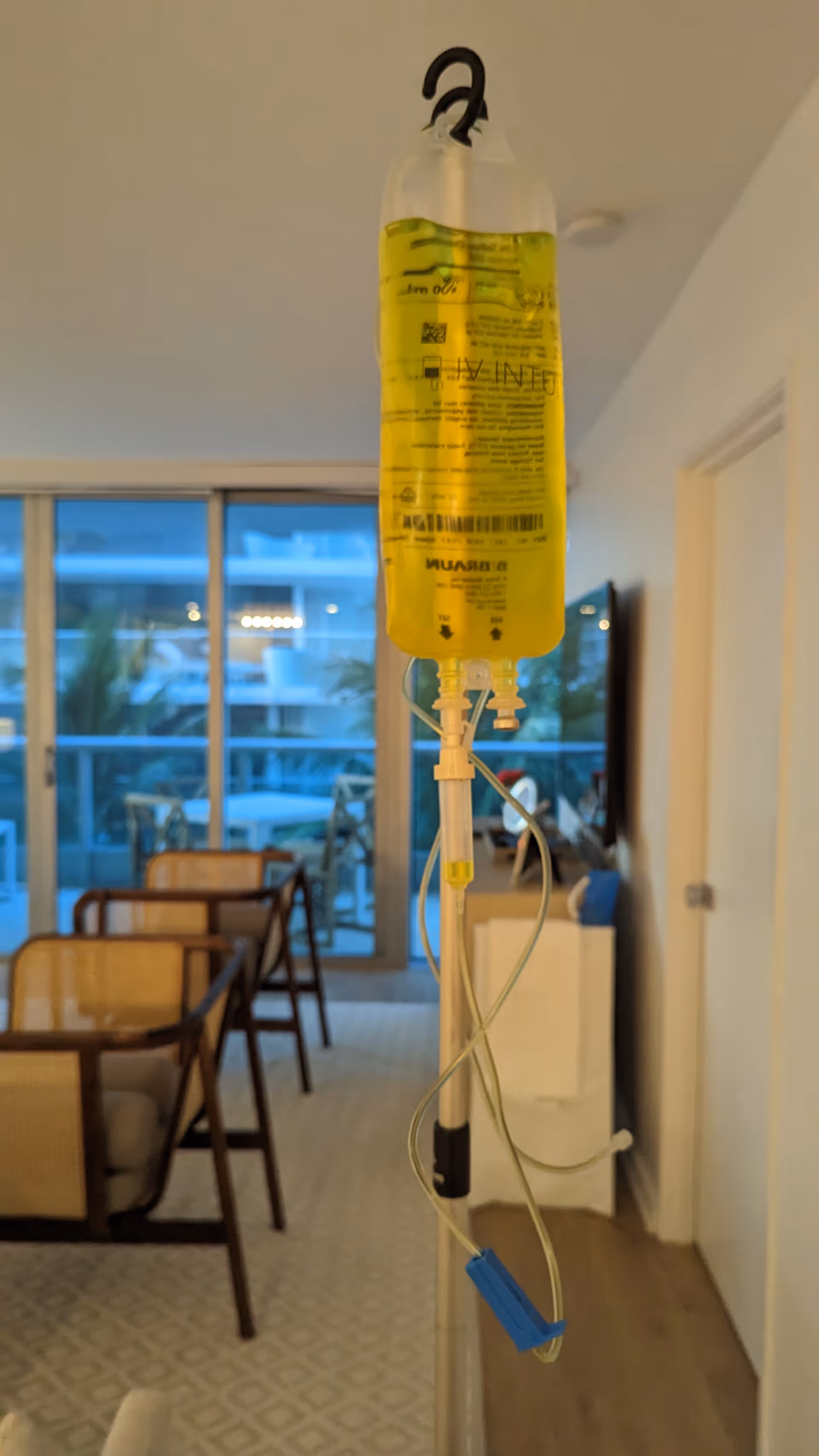 IV bag on a pole in a senior living interior near glass doors