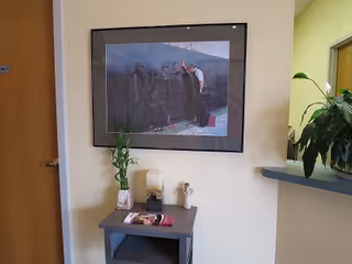 Hallway interior with framed photo, small table, candles, and potted plant decor.