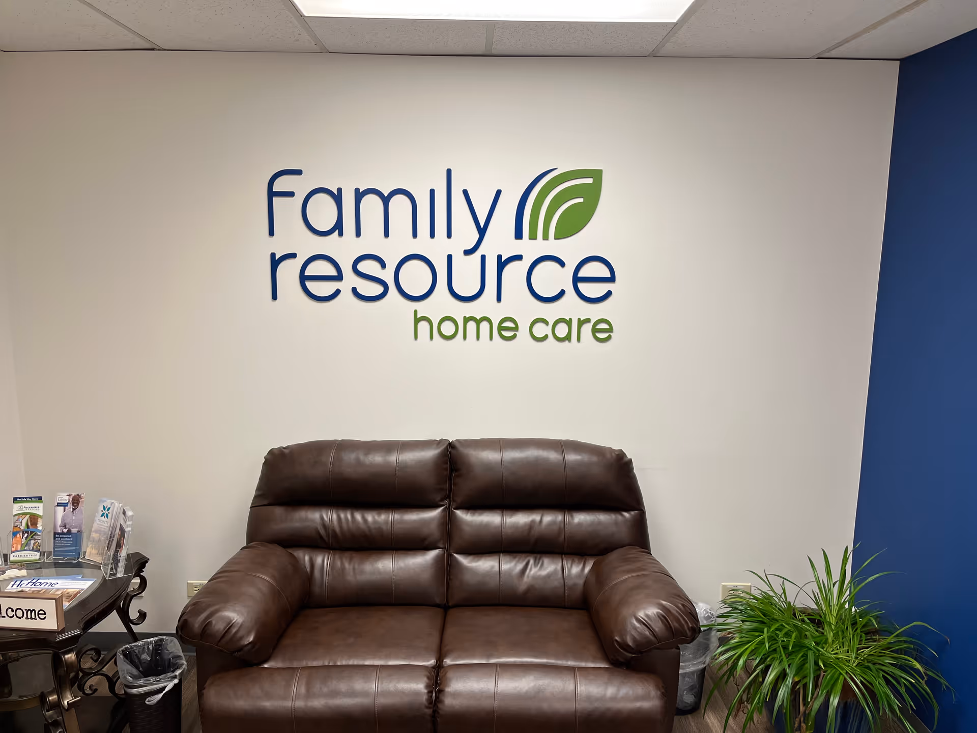 Lobby area with brown leather sofa and wall logo reading Family Resource Home Care.