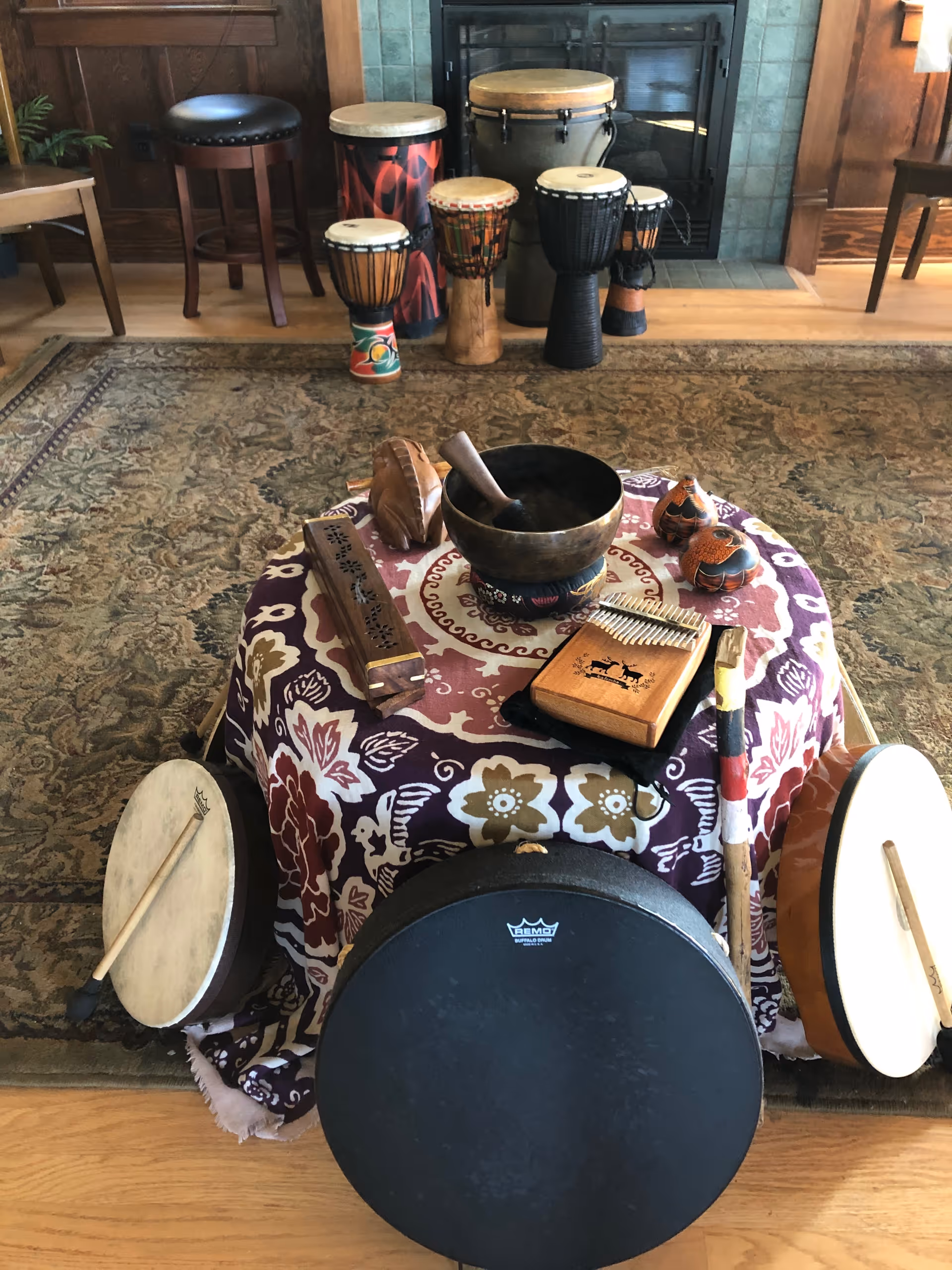 Cozy indoor room with various percussion instruments arranged on a patterned tablecloth.