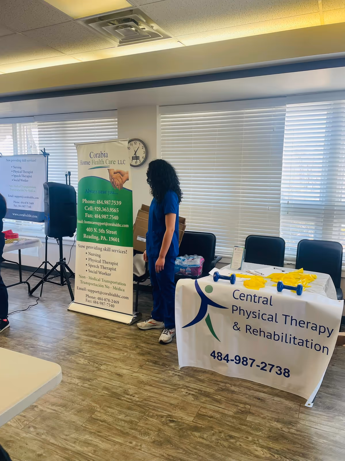 Indoor room with banners, a table, and a staff member in blue scrubs.