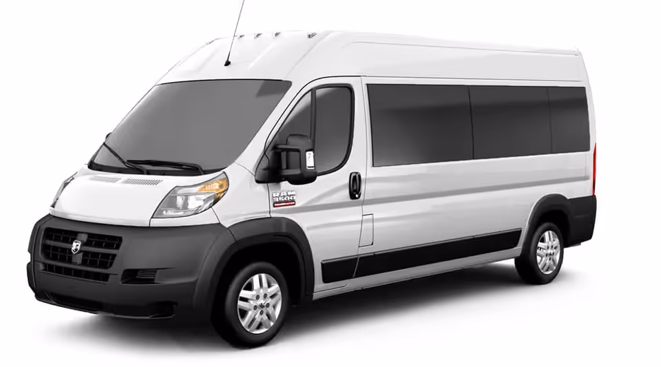 A white mobility van with tinted windows and a black bumper photographed from the side.