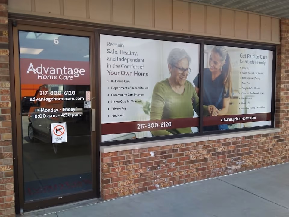 Brick storefront with large window ads for Advantage Home Care and contact details.
