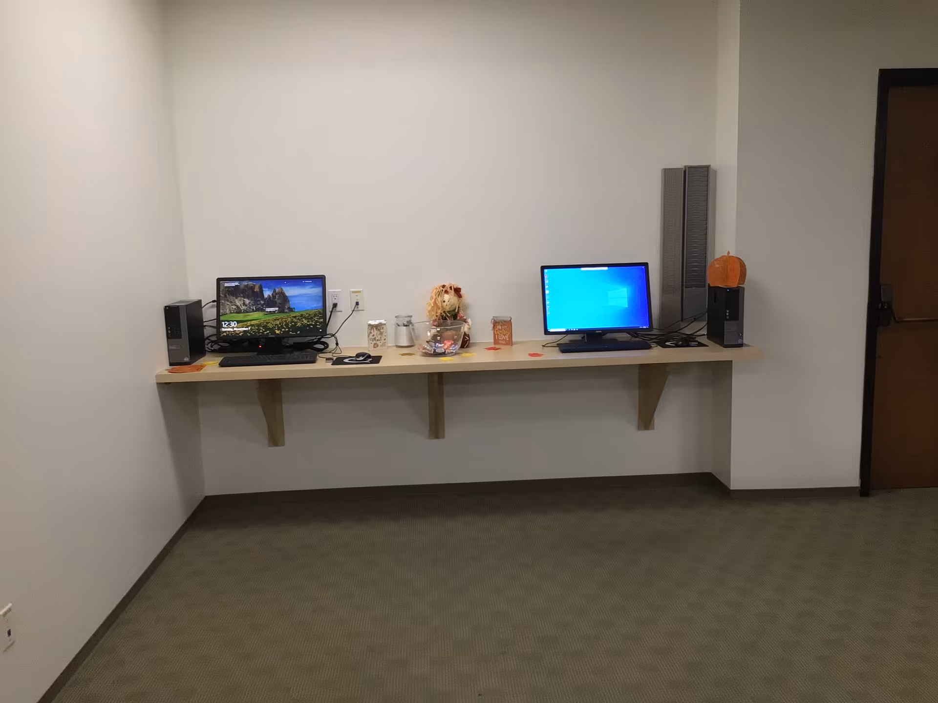 A long counter with two computer stations in a senior living facility room.
