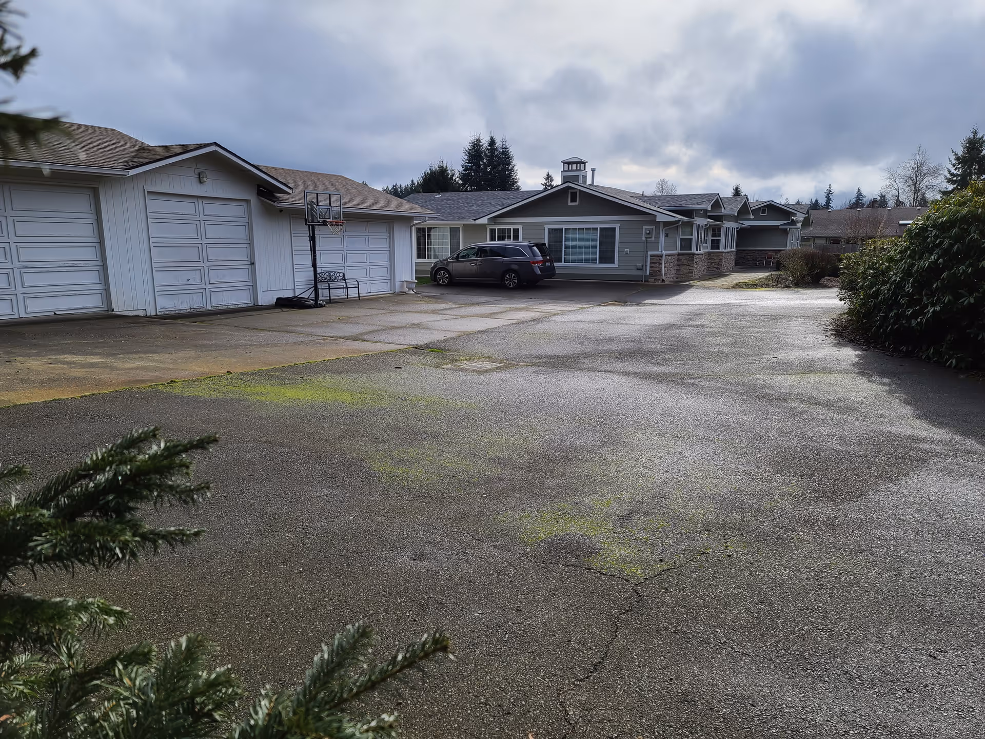 Exterior view of a suburban row of single-story homes with garages and driveways.