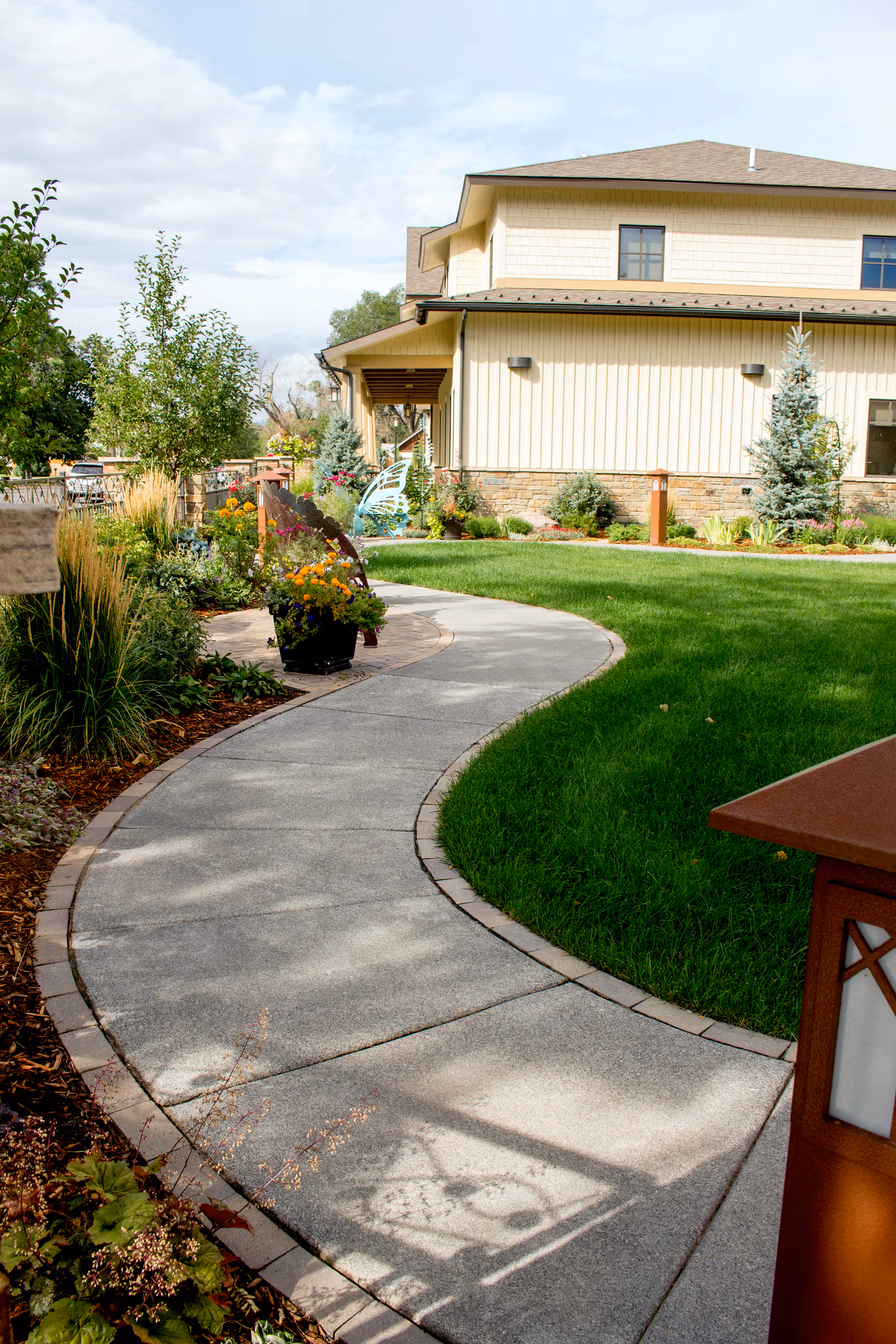 Exterior view of HopeWest Administrative Offices with a curved sidewalk, lawn, and landscaped garden.