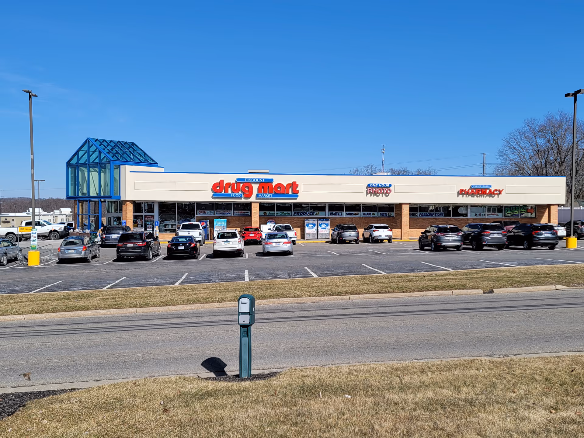 Front view of a Discount Drug Mart storefront with parking lot and blue sky.
