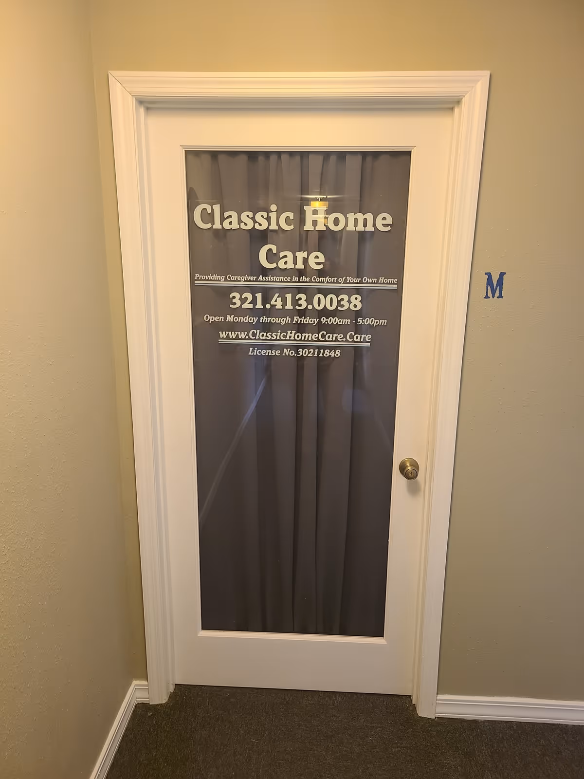 Interior door with Classic Home Care signage and curtains in a hallway.