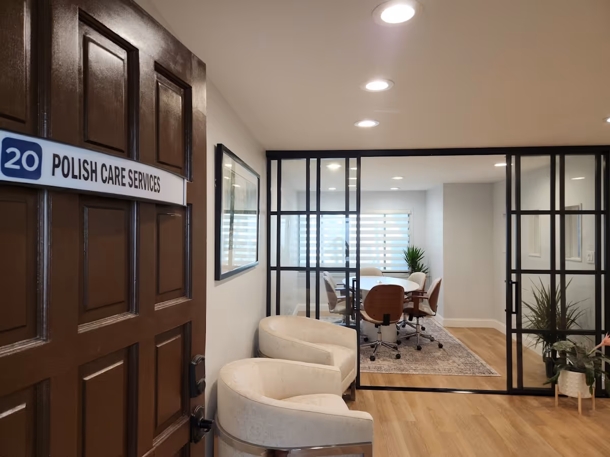 Door labeled Polish Care Services leads to a glass-walled conference room with chairs.
