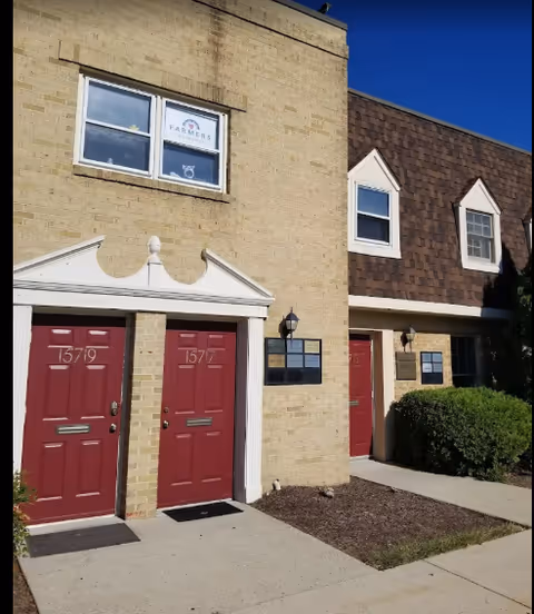 Exterior view of a Senior Helpers building with red doors and brick facade.