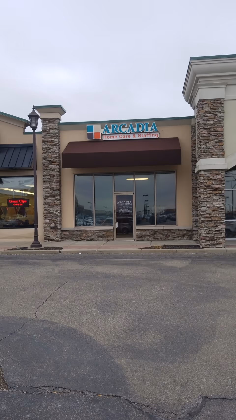 Front view of Arcadia Home Care & Staffing storefront with stone pillars and glass entrance.