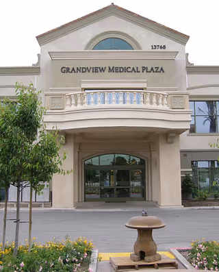 Exterior view of Grandview Medical Plaza entrance with arched balcony and glass doors.