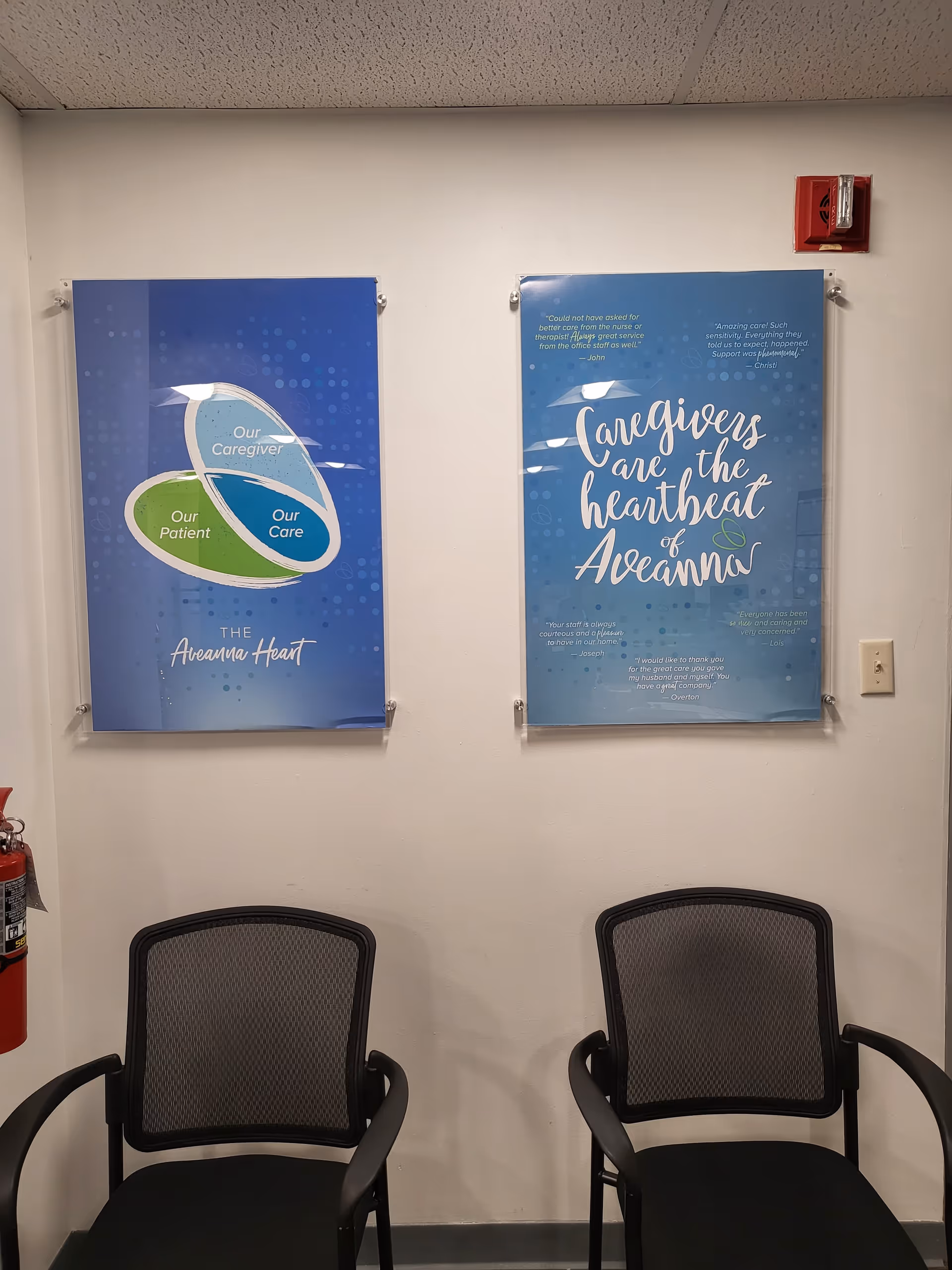 Two chairs sit in a hallway beside blue Aveanna posters on the wall.