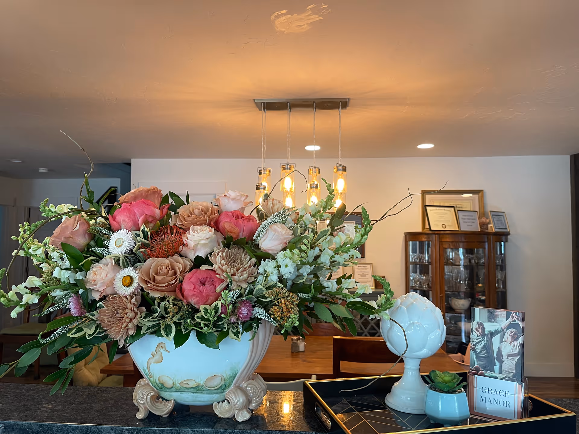 Large floral arrangement atop a reception counter in a warmly lit lobby.