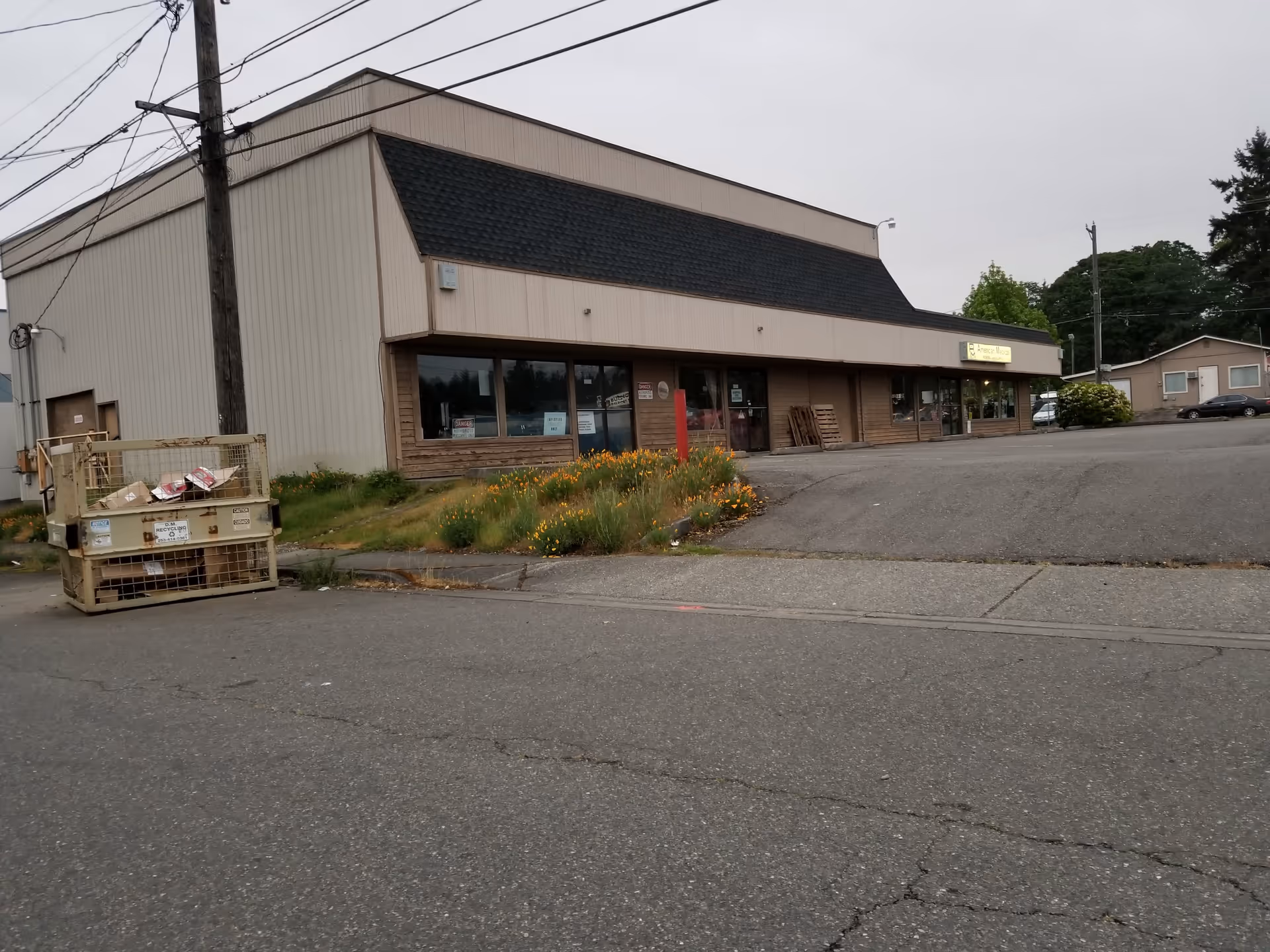 Exterior view of a single-story commercial building with a parking lot and landscaping.