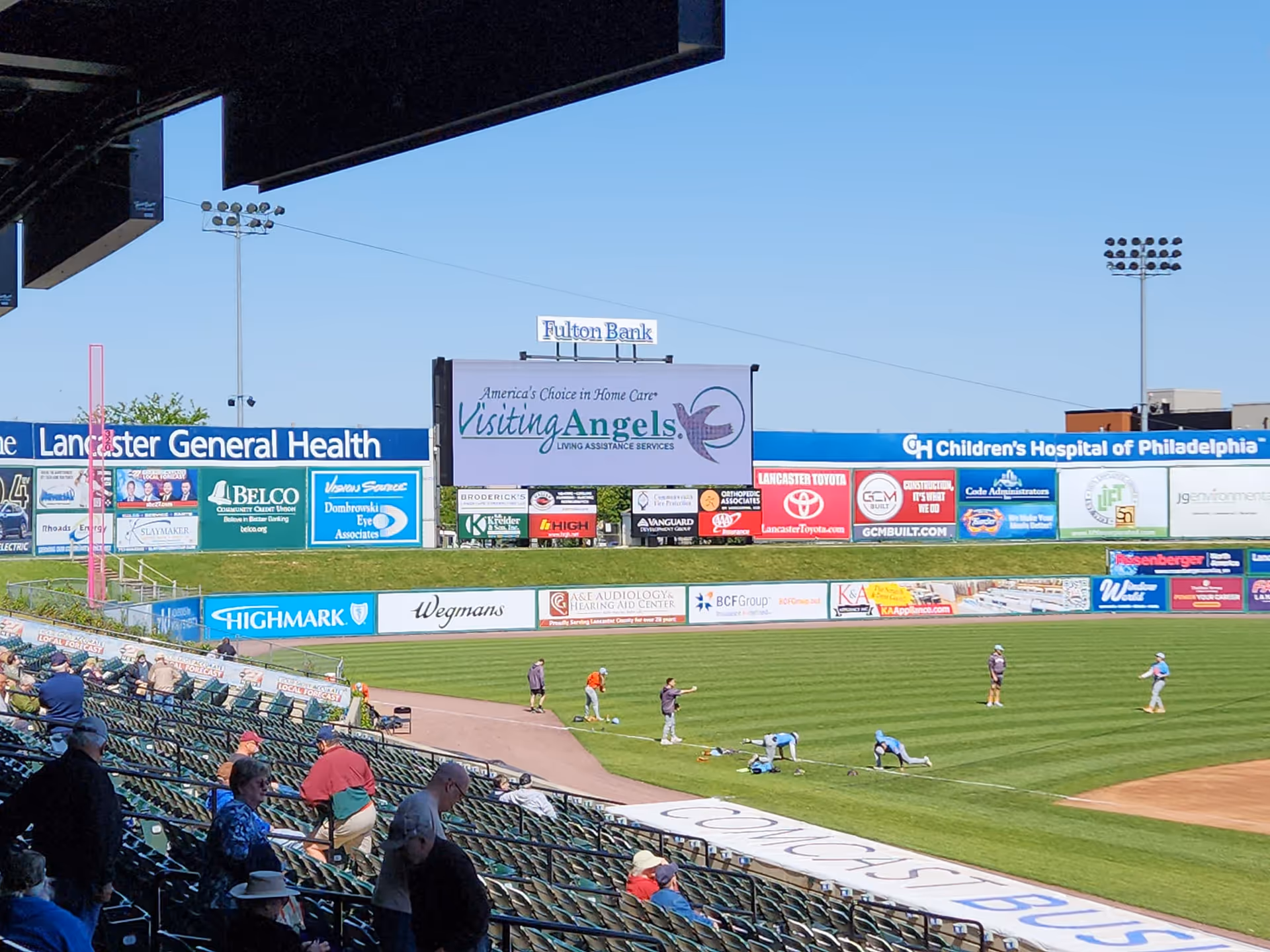 Outdoor baseball stadium featuring a large Visiting Angels sign among billboards.