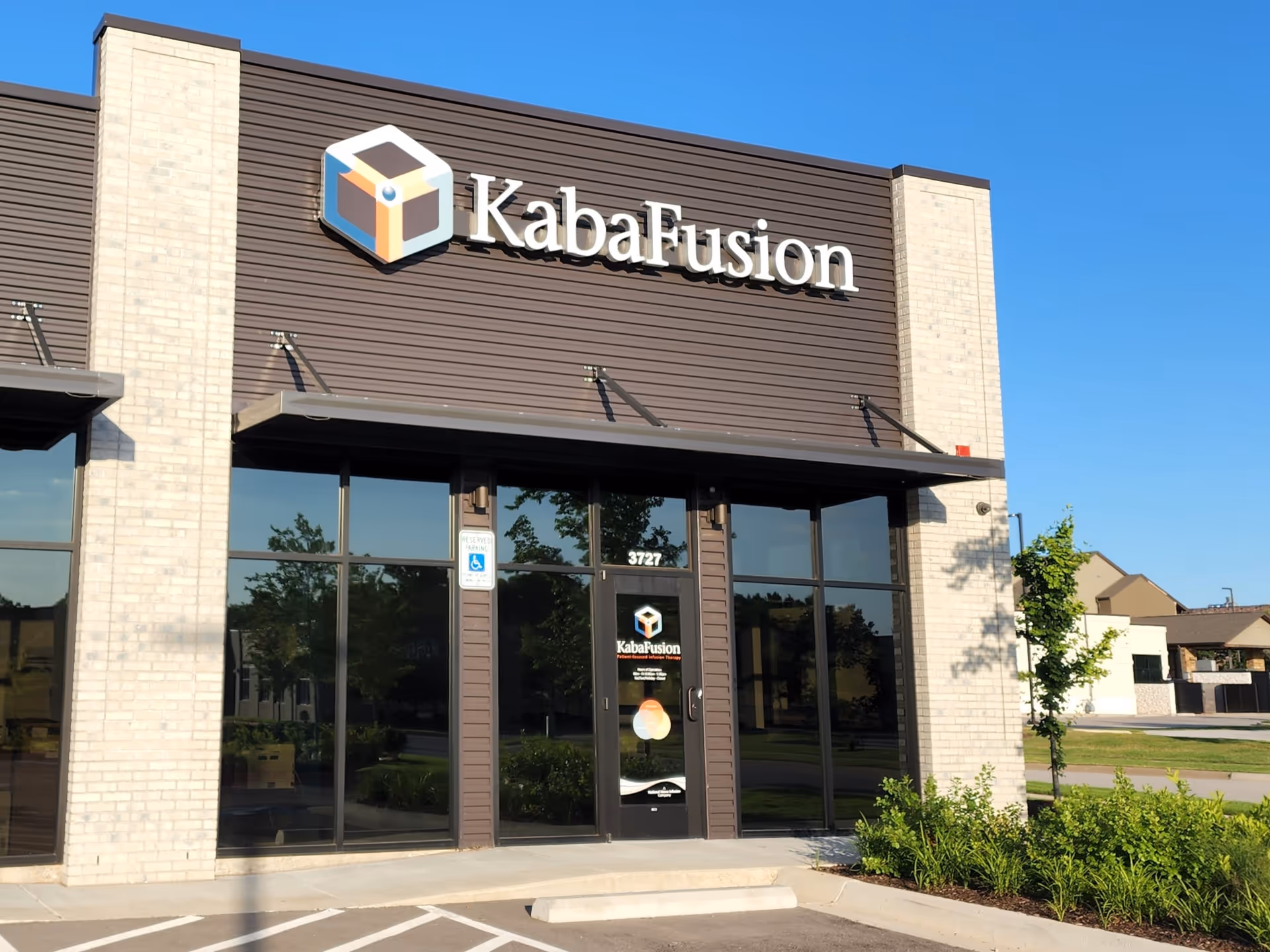 Facade of KabaFusion facility with glass doors and large sign on brick exterior.