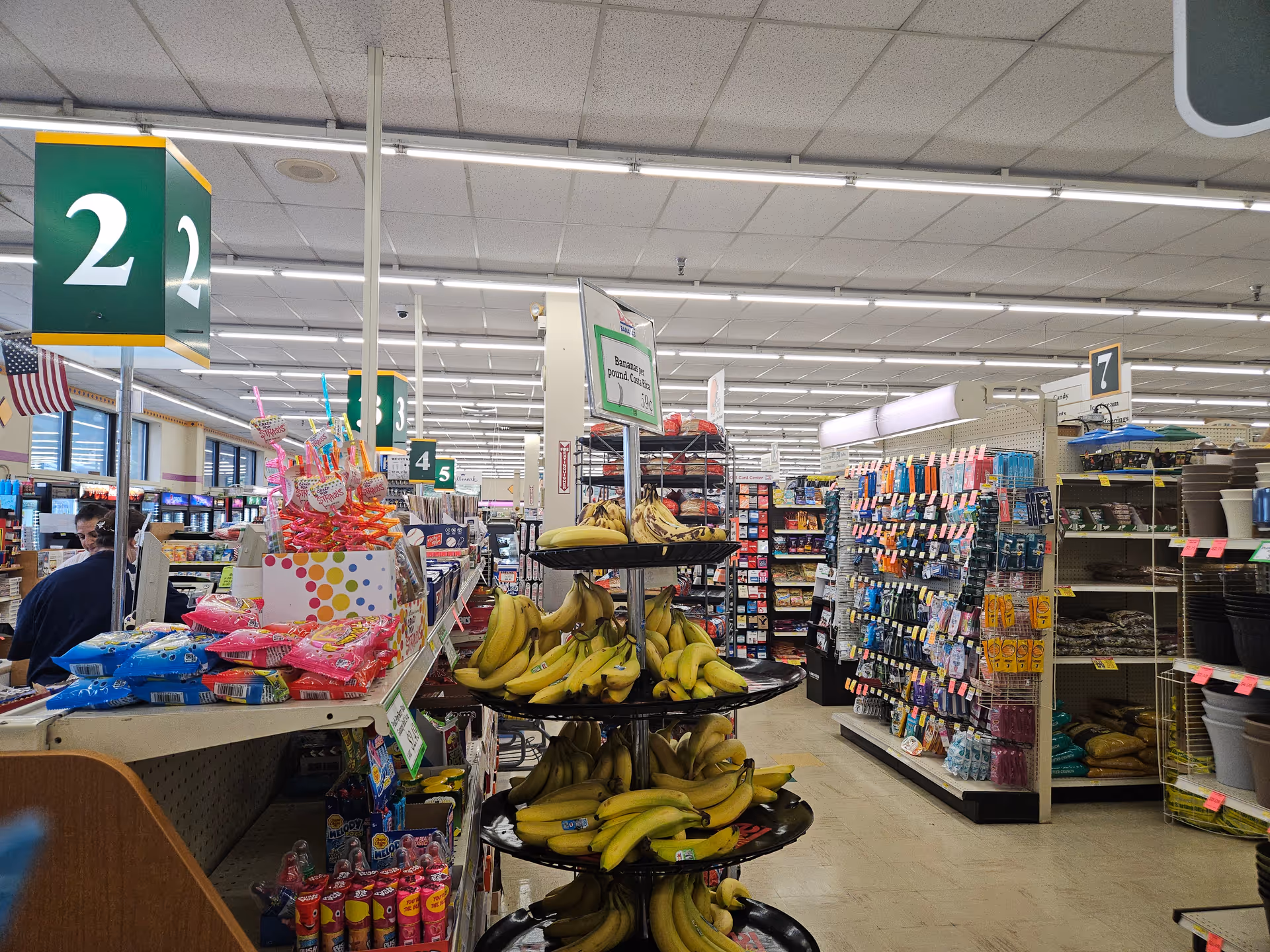 Inside Discount Drug Mart, a checkout area and central banana display amid store aisles.