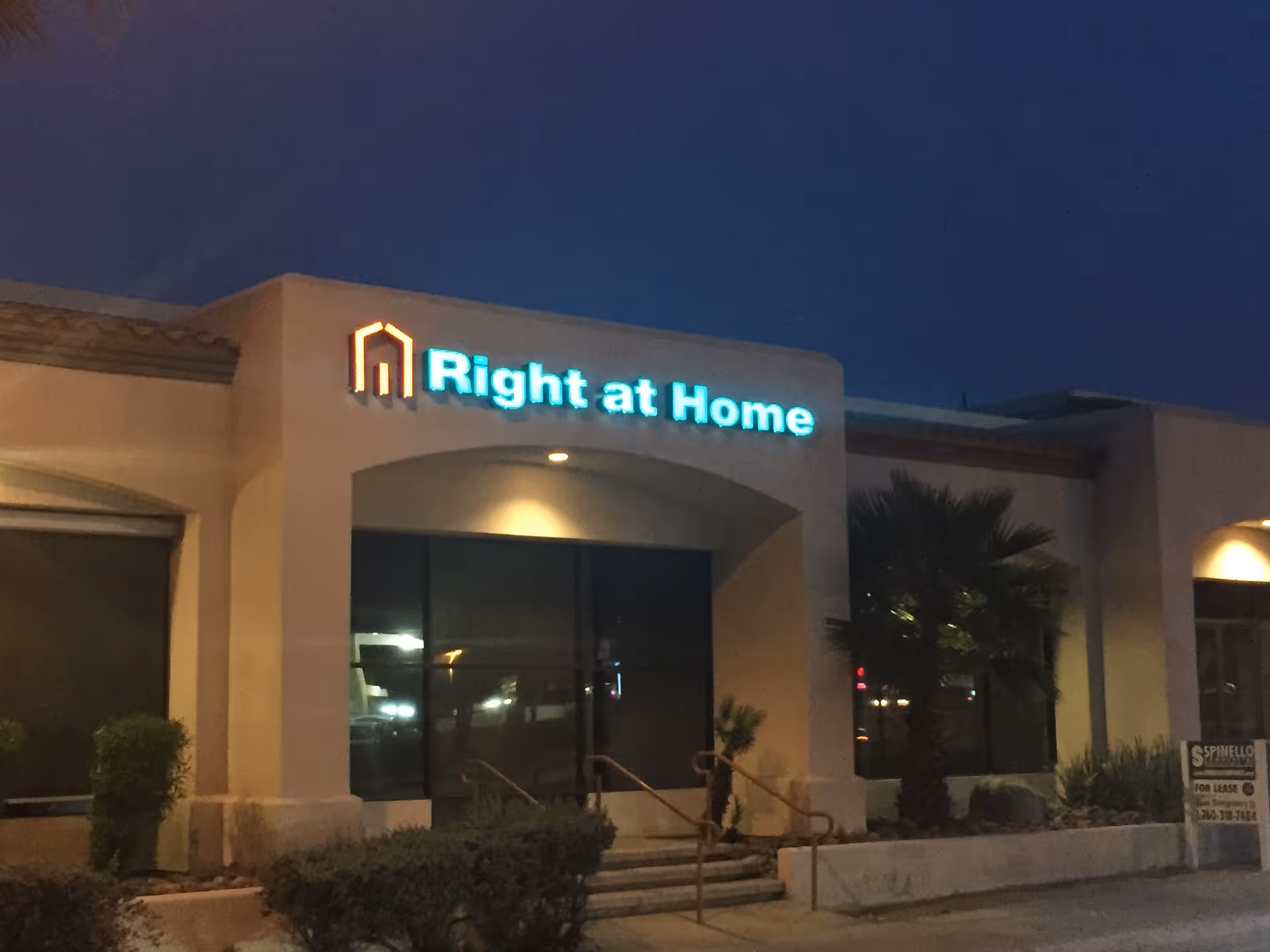 Night exterior of Right at Home facility with illuminated entrance sign.