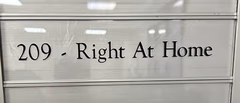 Metal sign reading 209 - Right At Home mounted on a metallic wall.