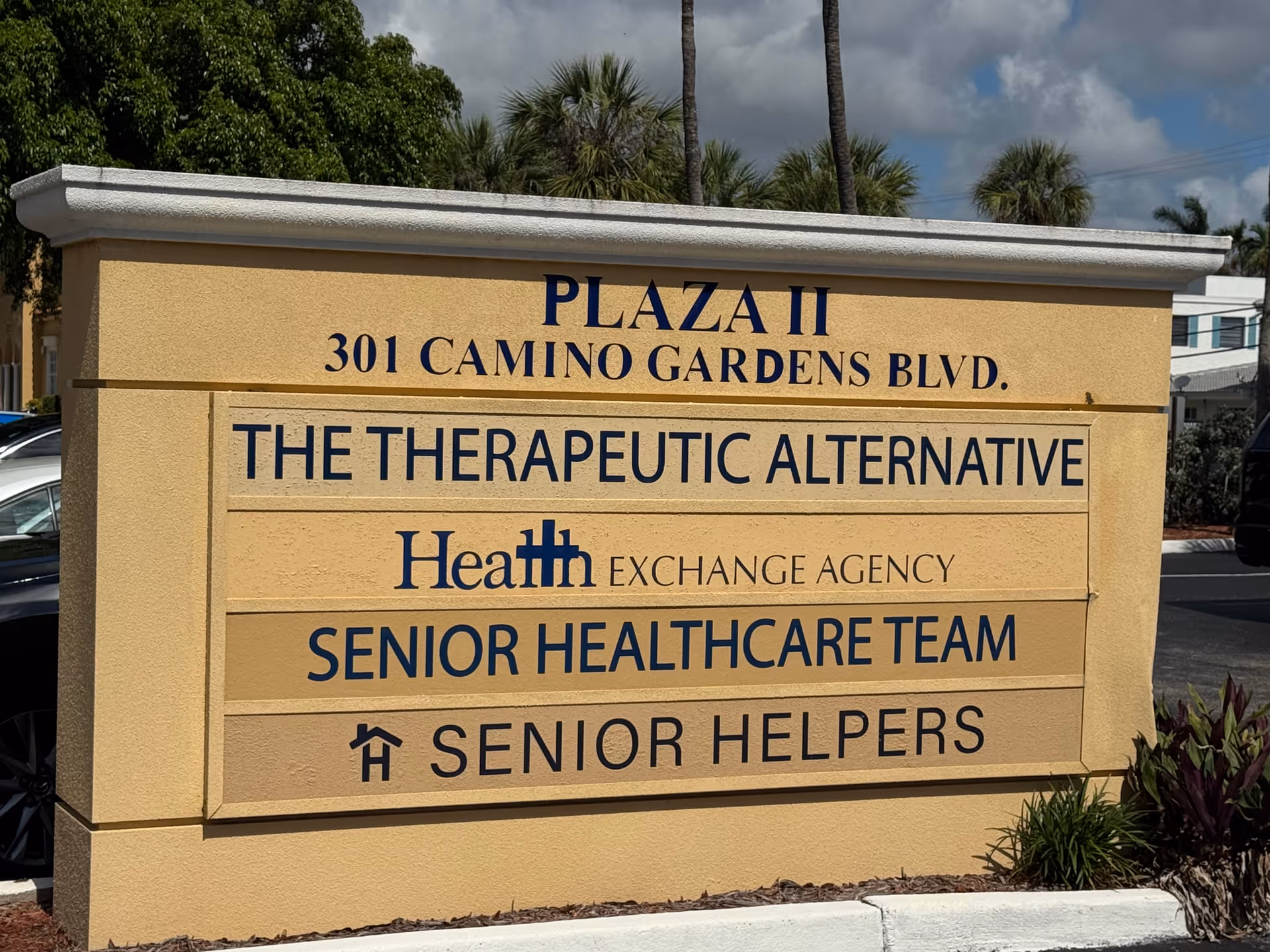 Beige outdoor sign on building front displaying Senior Helpers names.